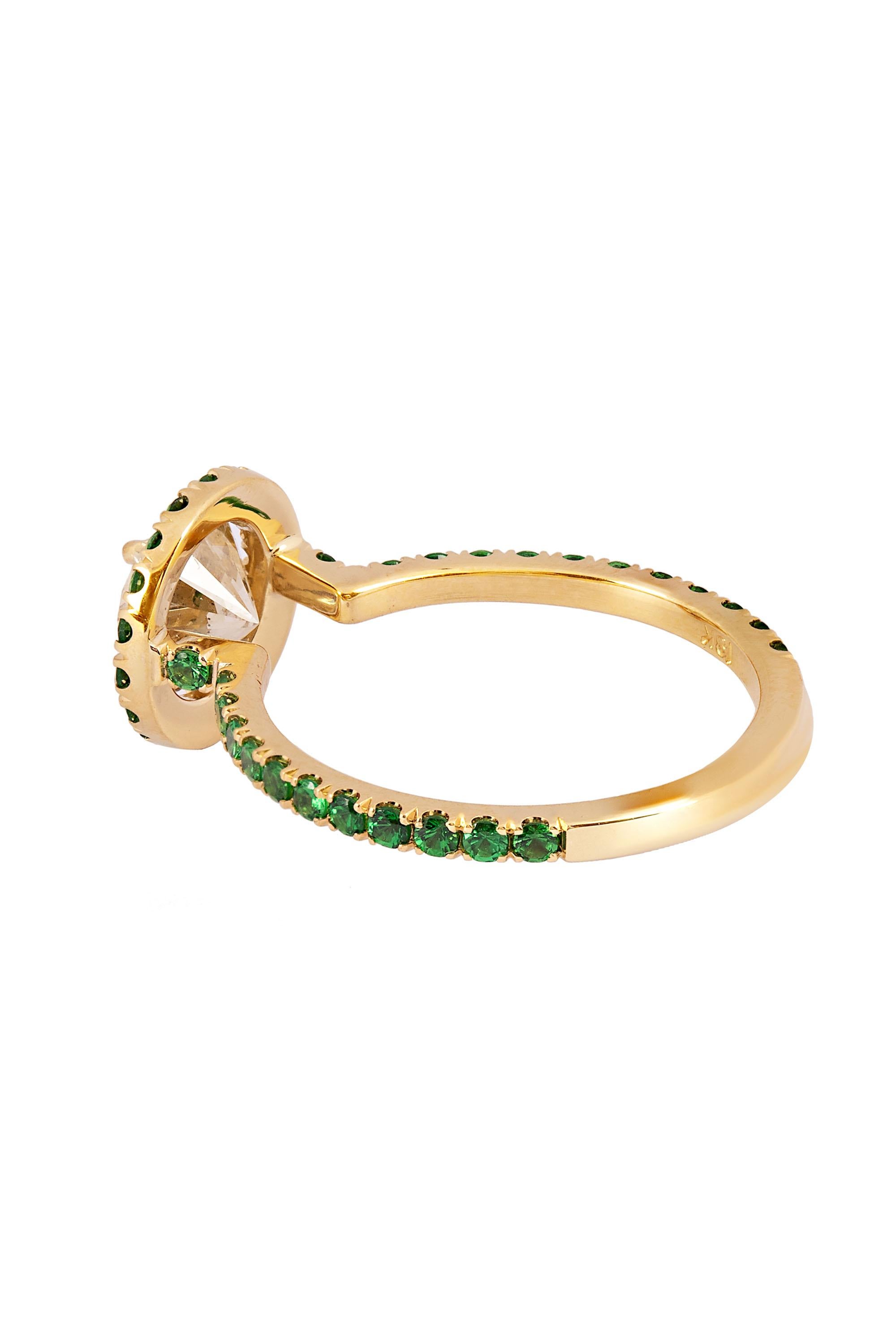 Designed and created by Gems Are Forever, Inc. Beverly Hills, this gleaming round brilliant diamond weighing 1.33 carats radiates from within a halo of round brilliant cut bright green tsavorite garnet which further accent the ring shoulders in this