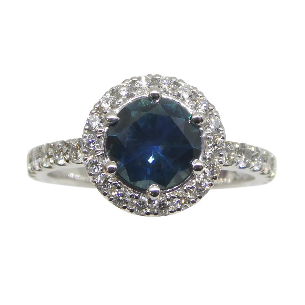 Embrace the enchantment of deep-sea hues with our 1.33ct Round Teal Blue Sapphire & Diamond Halo Ring, IGI certified and set in 18K White Gold. This radiant piece showcases Skyjems's commitment to superior craftsmanship passed down through three