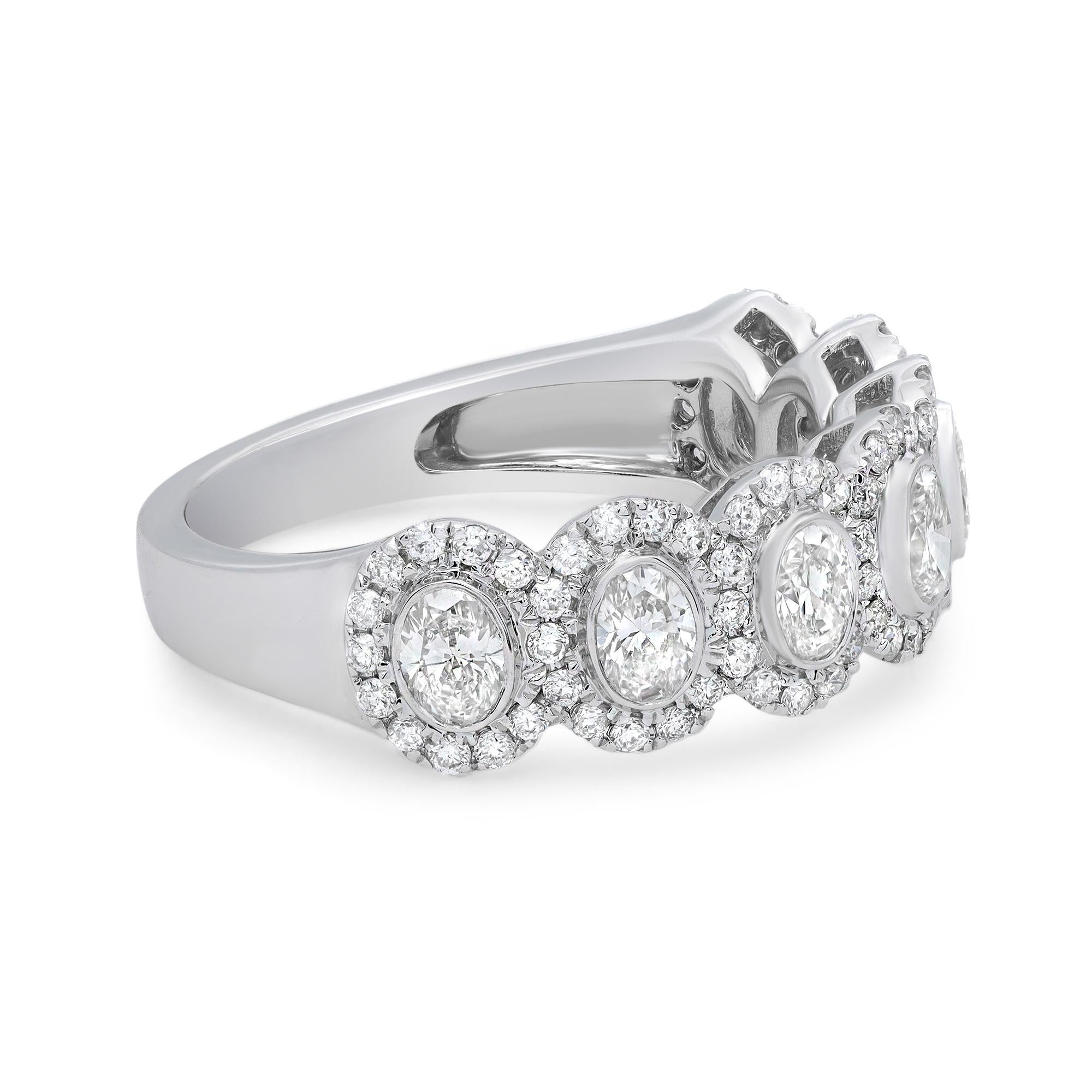 Stunning oval cut diamonds embraced by a halo of additional diamond accents in this enchanting ladies wedding band ring. Expertly crafted in 18K white gold. Total diamond weight: 1.33 carats. Diamond color H-J and clarity VS. Ring size: 6.5. Width:
