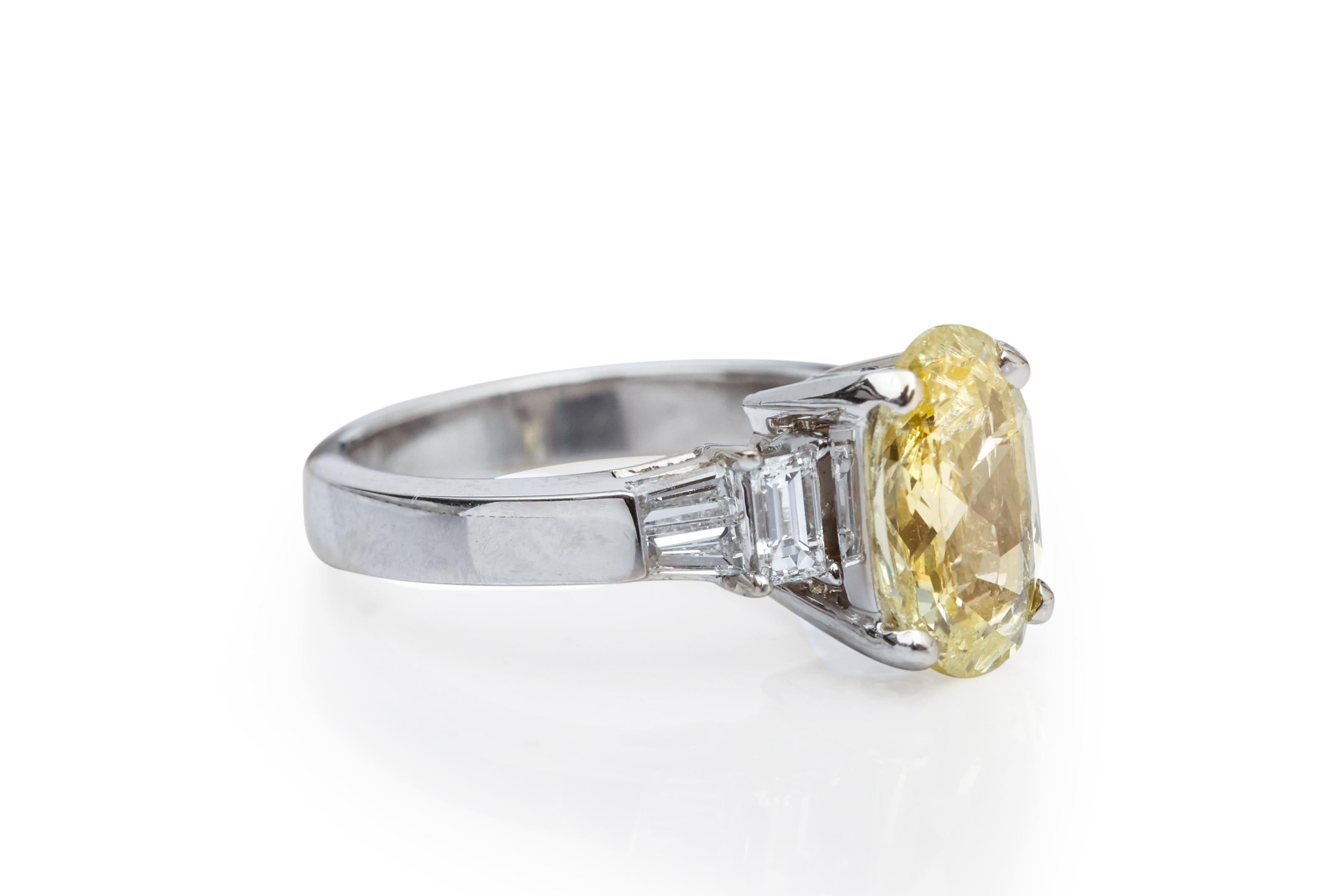 Item Details:
Metal type: Platinum
Weight: 6.9 grams
Ring Size: 4 (resizable)

Diamond Details:
Center Diamond - Canary Yellow
Cut: Oval
Carat: 1.34 carats
Color: Canary Yellow
Clarity: I1

Accent Diamond Details:
Cut: Emerald Cut
Color: G
Clarity: