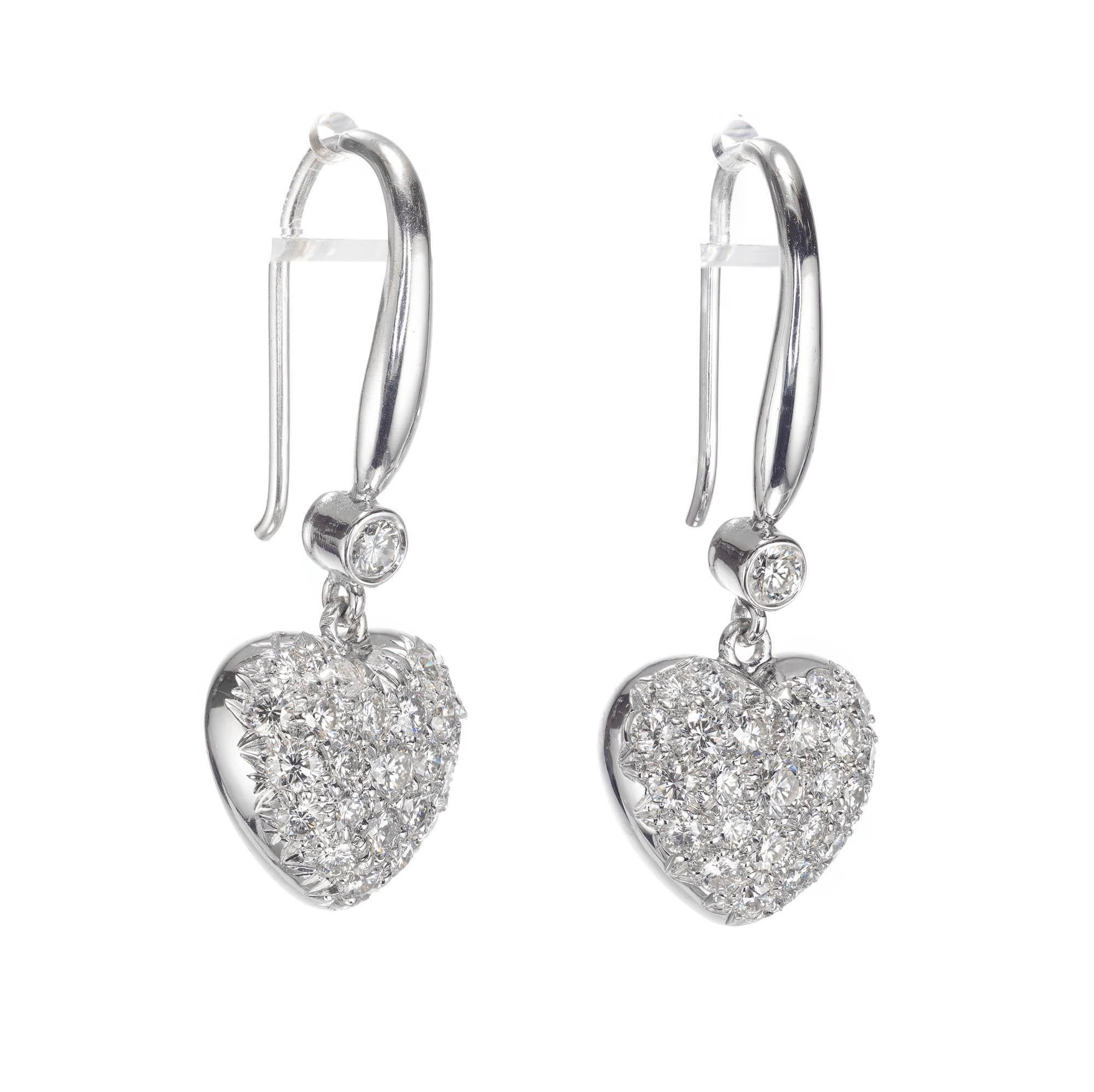 Pave diamond heart dangle earrings in 18k white gold 

48 round brilliant cut H-I SI diamonds, Approximate 1.20 carats 
2 round brilliant cut H-I SI diamonds, Approximate .14 carats 
18k White Gold 
Stamped: 18k
6.7 Grams
Top to Bottom: 30mm or 1 ¼