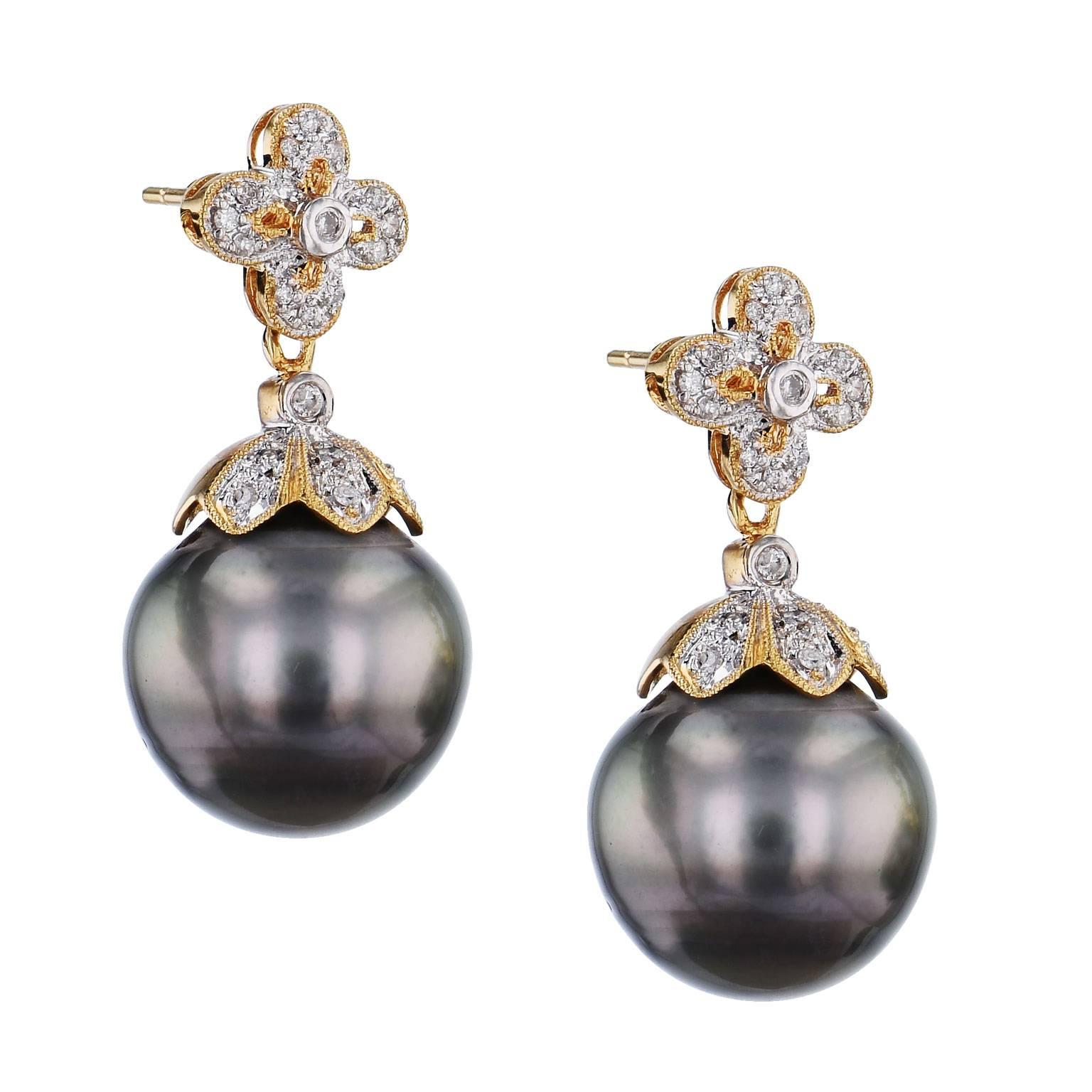 13.40 millimeter Tahitian pearls catch the eye as 0.25 carat of pave-set diamond (G/H/SI) in ornate embellishment dazzle in these previously loved 18 karat yellow gold drop earrings.