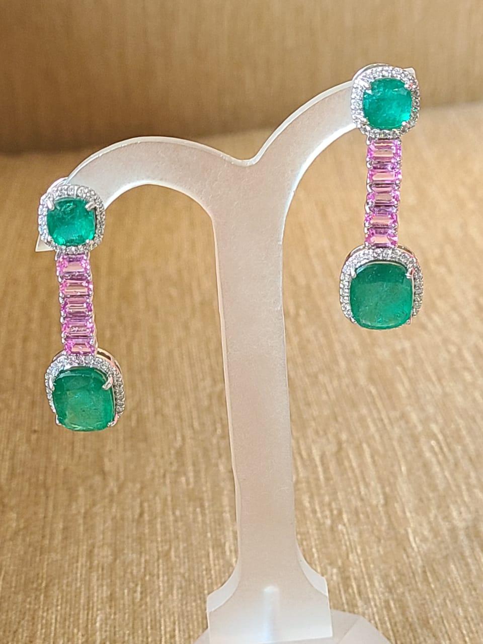 A very gorgeous Emerald and Pink Sapphire Dangle/ Drop earrings set in 18K Gold & Diamonds. The weight of the Emerald is 13.44 carats. The Emeralds are completely natural, without any treatment and of Zambian origin. The weight of the Pink Sapphires
