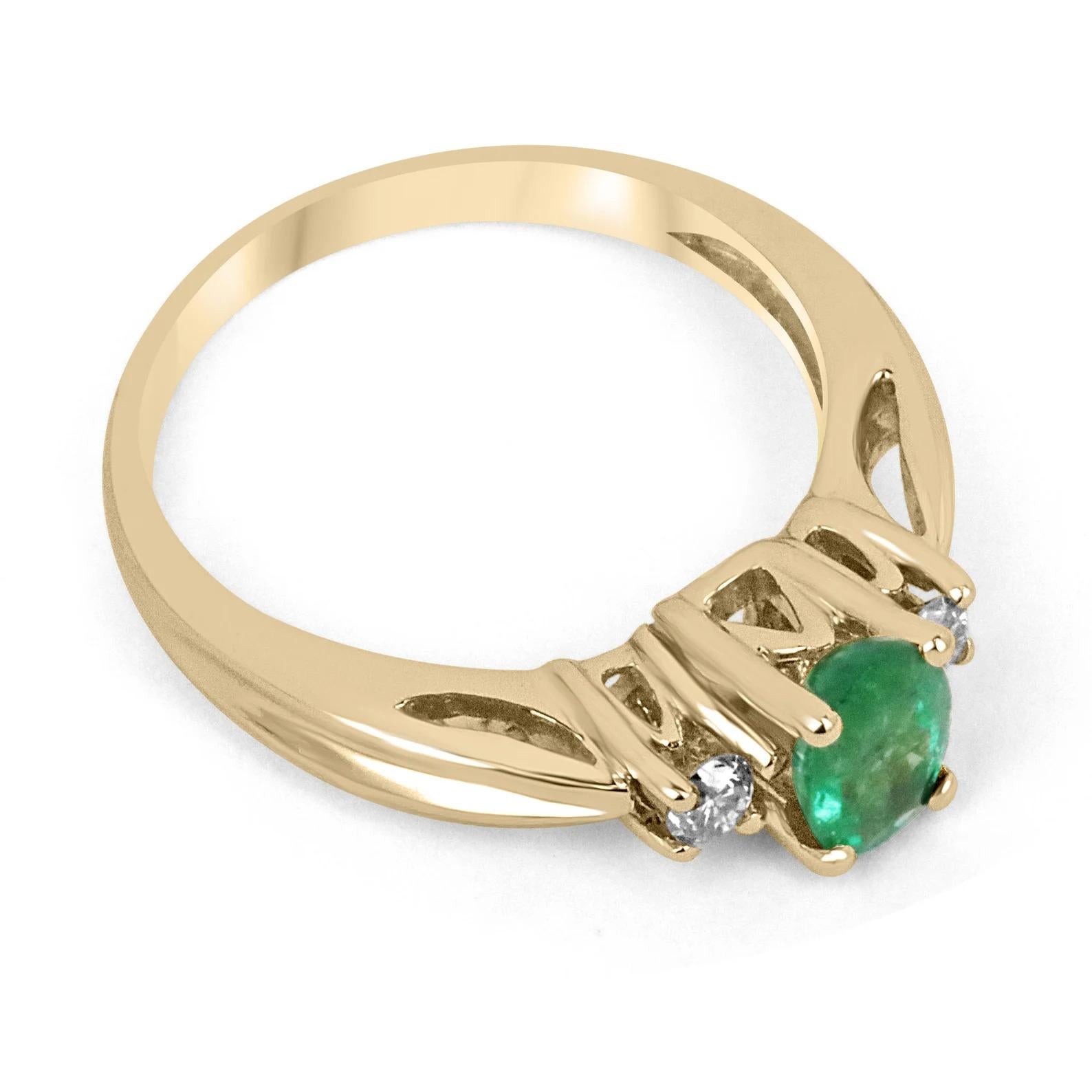 A classic emerald and diamond three-stone ring. Dexterously crafted in gleaming 14K gold this ring features a 1.17-carat natural emerald-oval cut from the origins of Zambia. Set in a secure prong setting, this extraordinary emerald has a medium dark