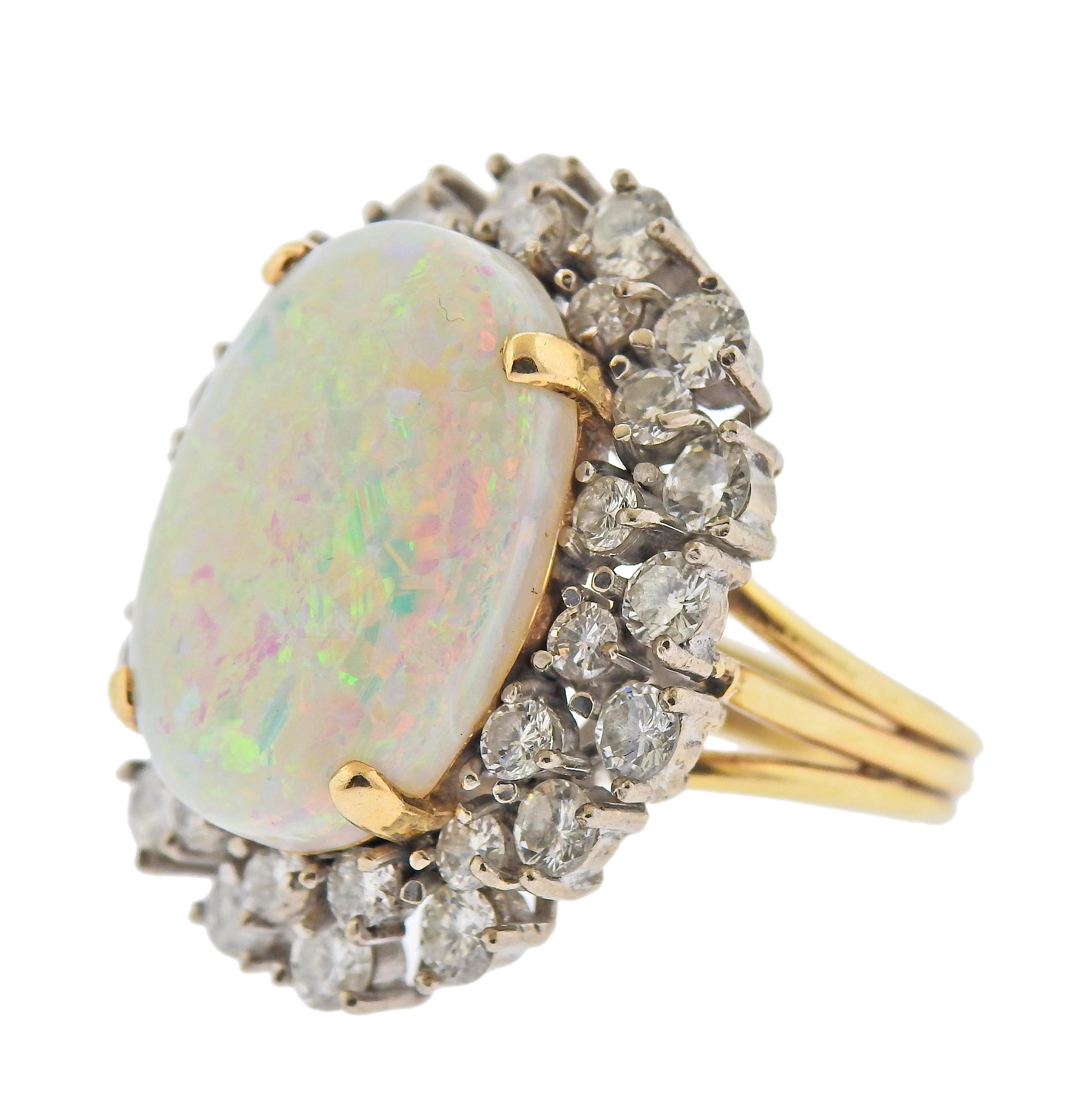 14k gold cocktail ring with approx. 13.5 carat oval opal, measuring 21.3 x 15 x 7.35mm, surrounded with approx. 3.20ctw in diamonds. Ring size - 8, ring top - 30mm x 25mm. Marked: 14k. Weight - 15.6 grams. 