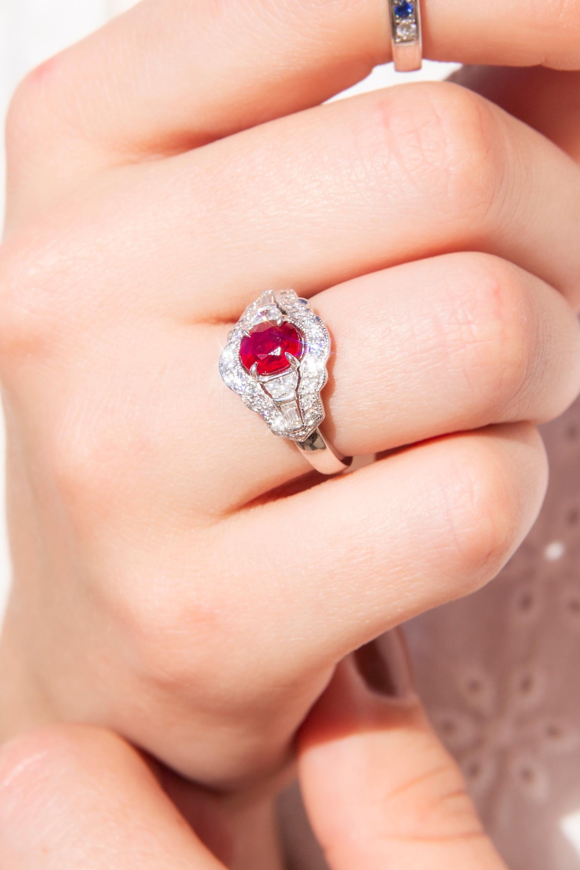 Thoughtfully handcrafted in gleaming 18 carat white gold, this fabulous contemporary cluster ring is absolutely exquisite. The high polish band holds a stunning gallery with a vibrant oval red ruby in an elegant four-claw setting. The ruby is