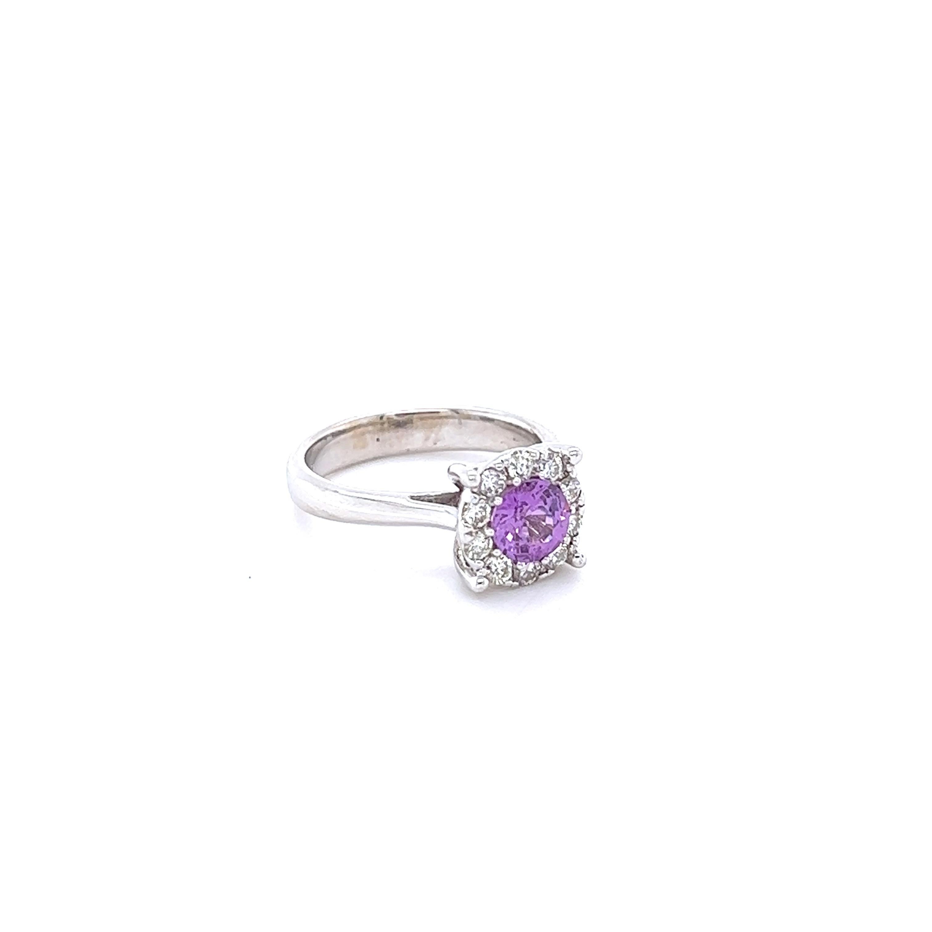 This beautiful ring has a Natural Round Cut Pink Sapphire that weighs 0.98 Carats and measures at approximately 6 mm. 

The ring is embellished with 10 Round Cut Diamonds that weigh 0.54 Carats with a clarity and color of VS2/H.
The total carat