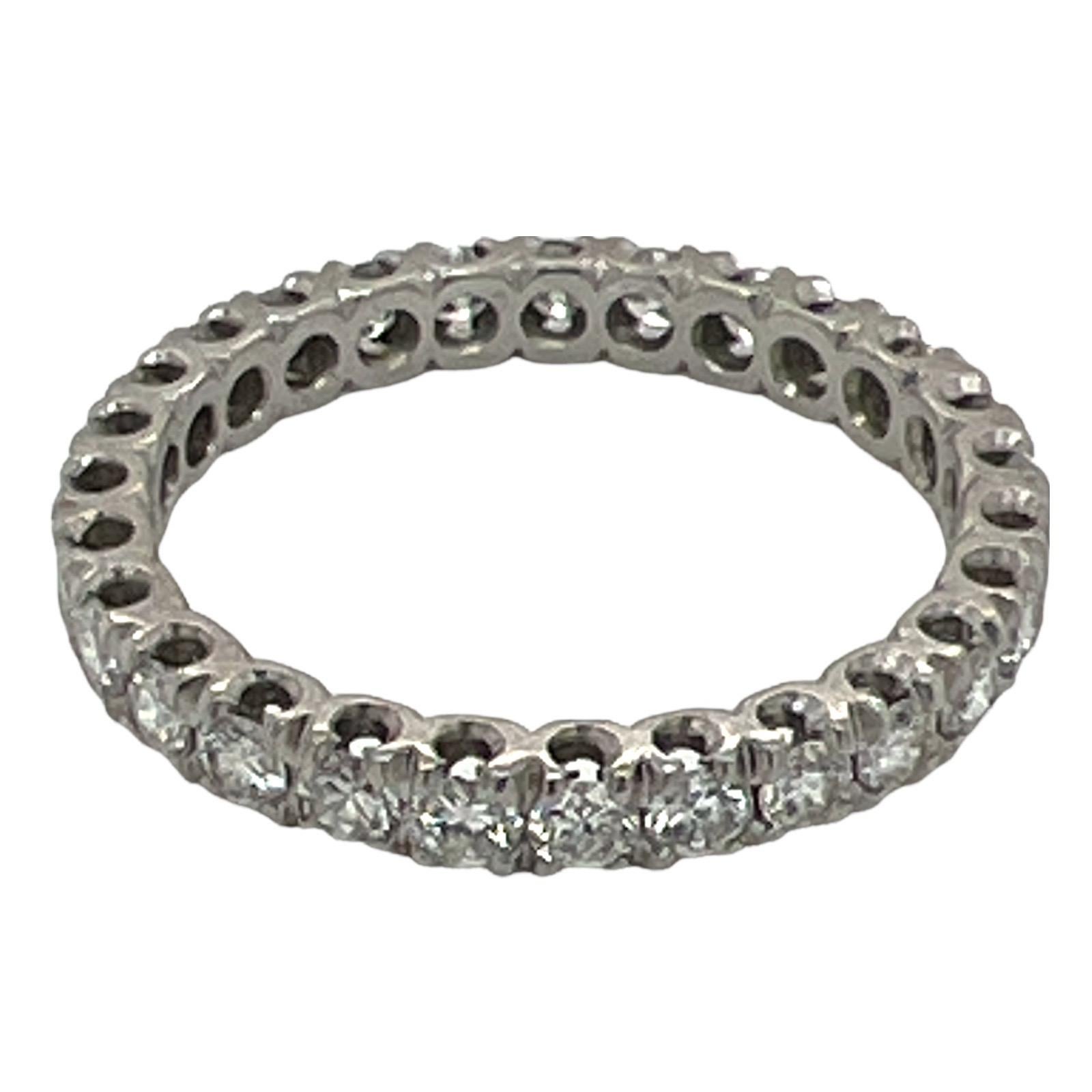 Diamond wedding eternity band crafted in platinum. The ring is set with 27 round brilliant cut diamonds weighing approximately 1.35 carat total weight. The diamonds are graded G-H color and VS clarity. The shared prong mounting measures 2.8mm in