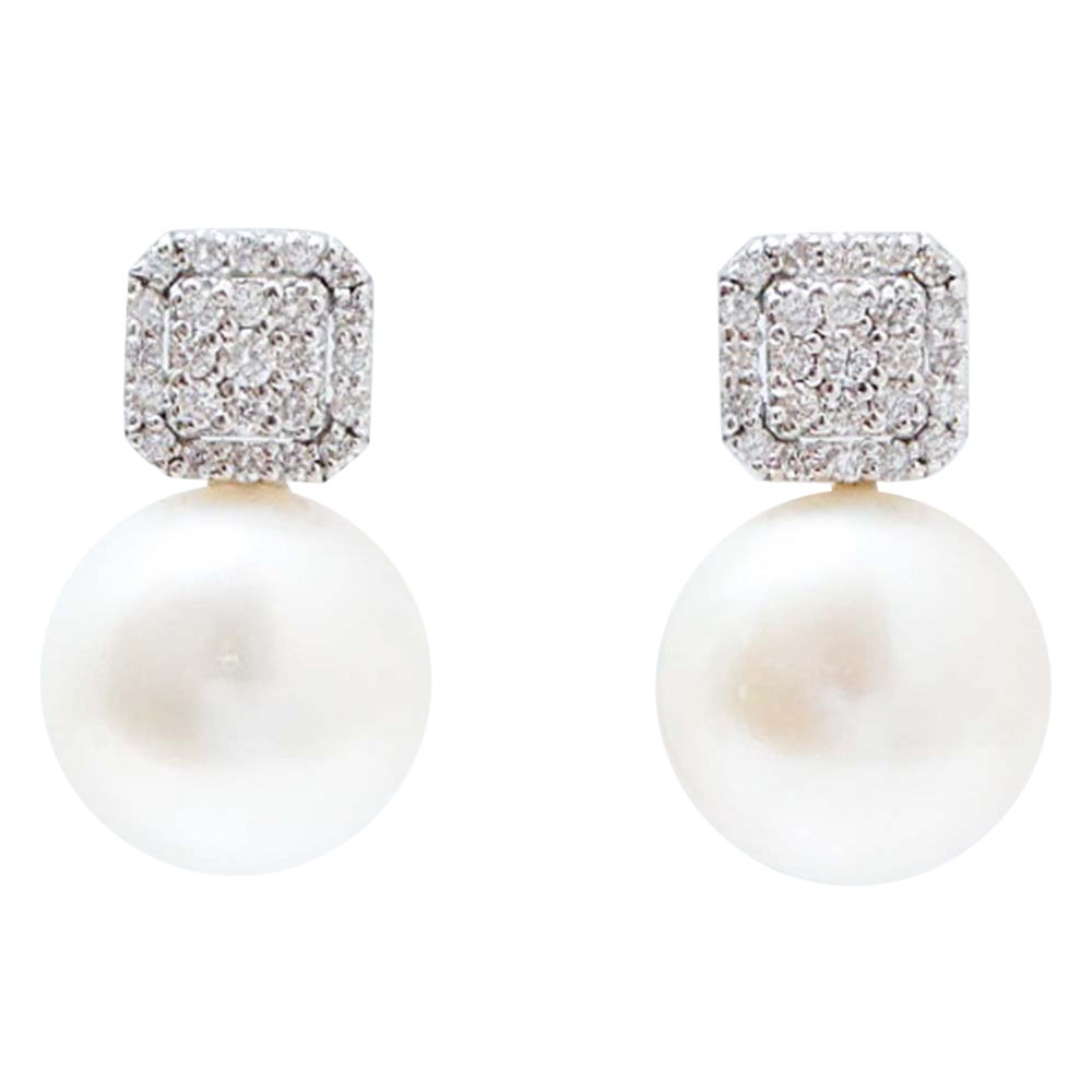 Orecchini con perle da 13,5 mm, diamanti e oro bianco da 18 carati.