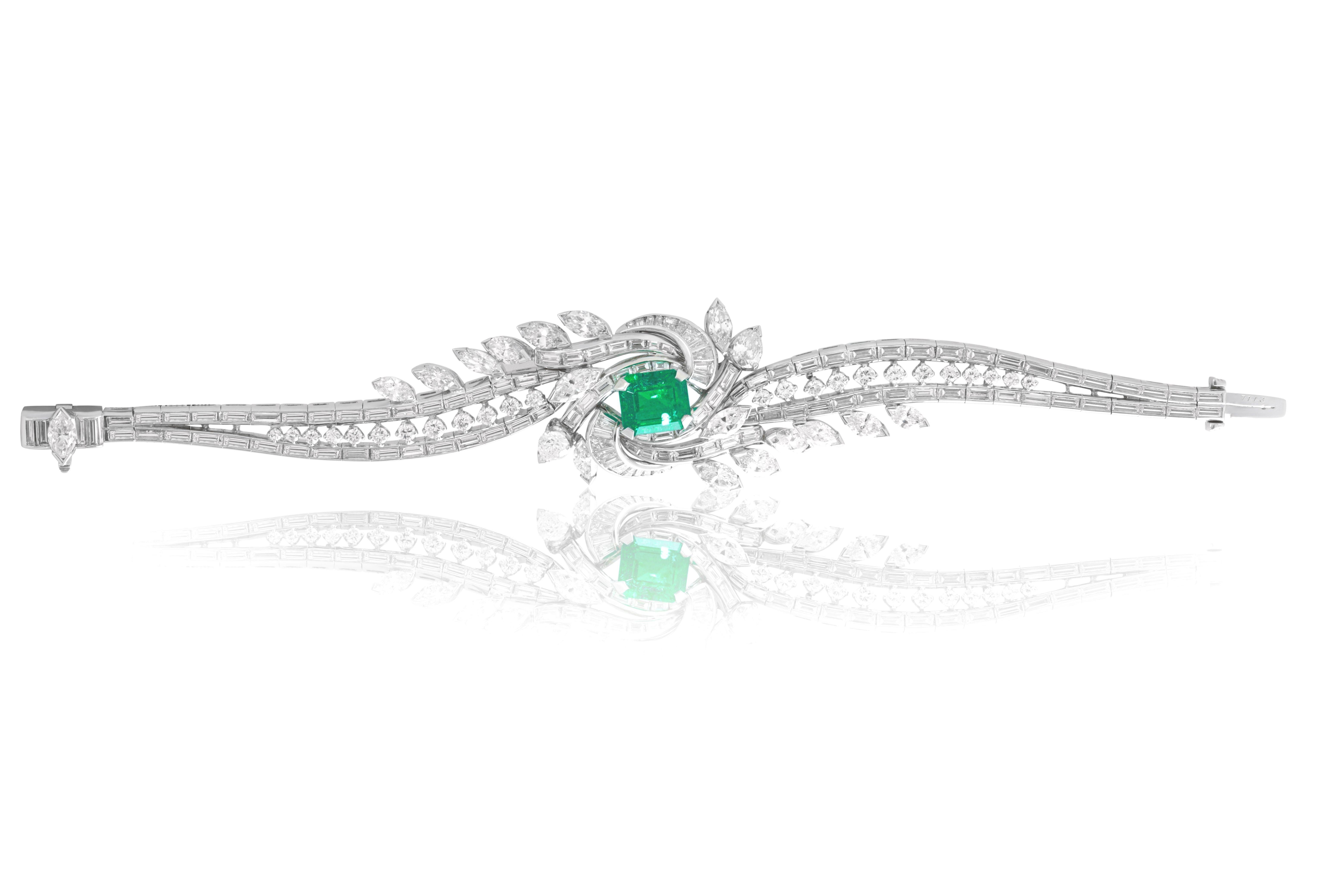 Platinum fashion bracelet with a center whirlpool-shaped design adorne with emerald cut diamonds surrounding a 3.05 cts tw square cut emerald and a center row of round diamonds surrounded with 2 rows of emerald cut diamonds encircling the bracelet