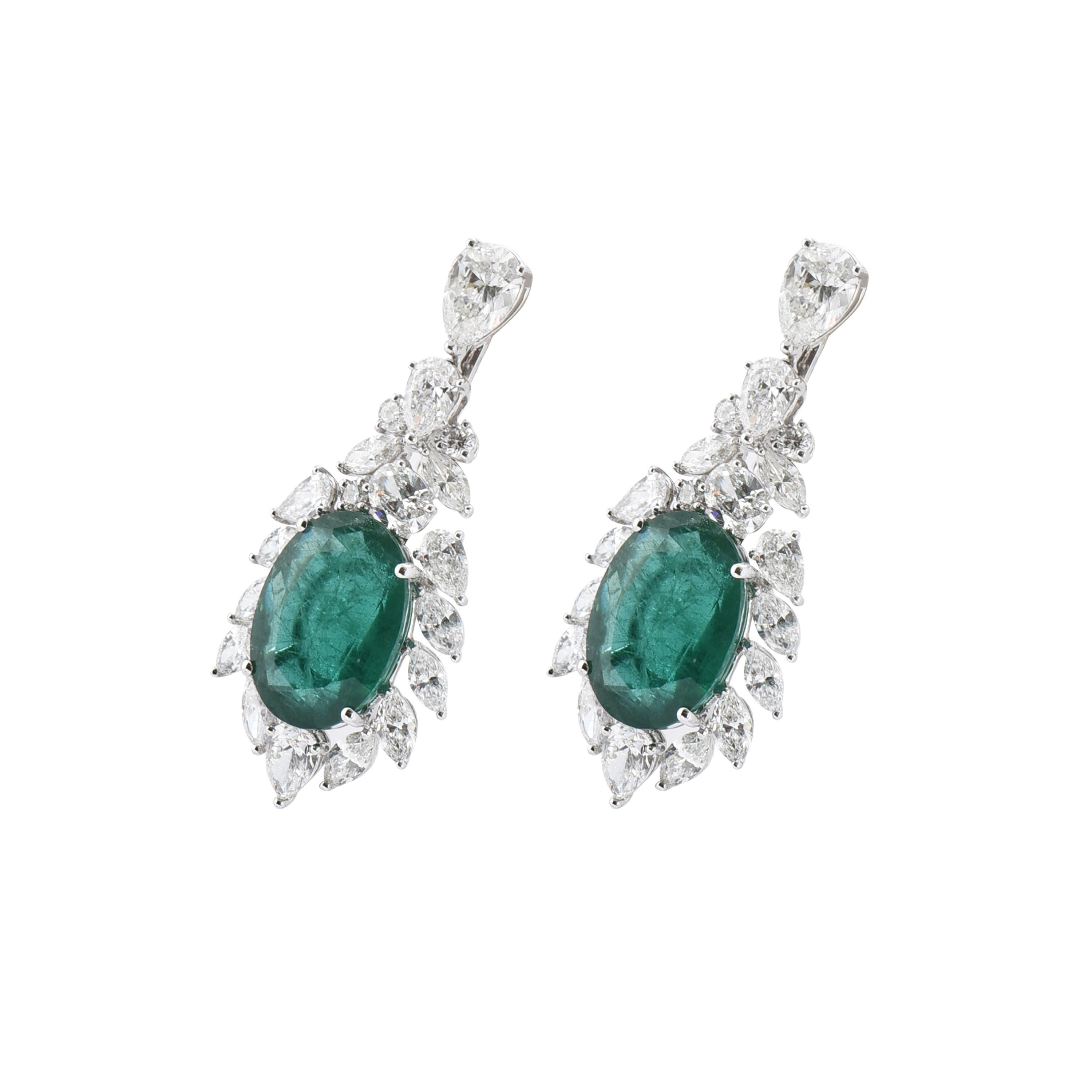 A pair of 18 karat white gold emerald earrings from the Viridian collection of Laviere. The earrings are set with two oval shape emeralds weighing a total of 13.59 carats, 3.41 carats pear shape brilliant-cut diamonds, 2.69 carats marquise shape