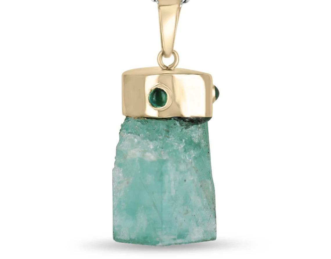 Showcased is a natural, rough emerald crystal pendant. An estimated 135 total carat weight of genuine, rough, Colombian emerald crystal is beautifully set in a hand-made 14K yellow gold cap. The Colombian emerald has a medium light green color has
