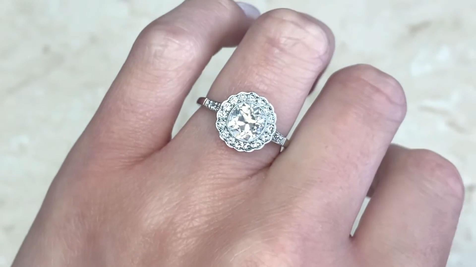 Este exquisito anillo en racimo de diamantes exhibe en su centro un impresionante diamante de talla europea antigua de aprox. 1,30 quilates, de color J y claridad excepcional VS1. Alrededor de la pieza central hay un halo de diamantes adicionales de