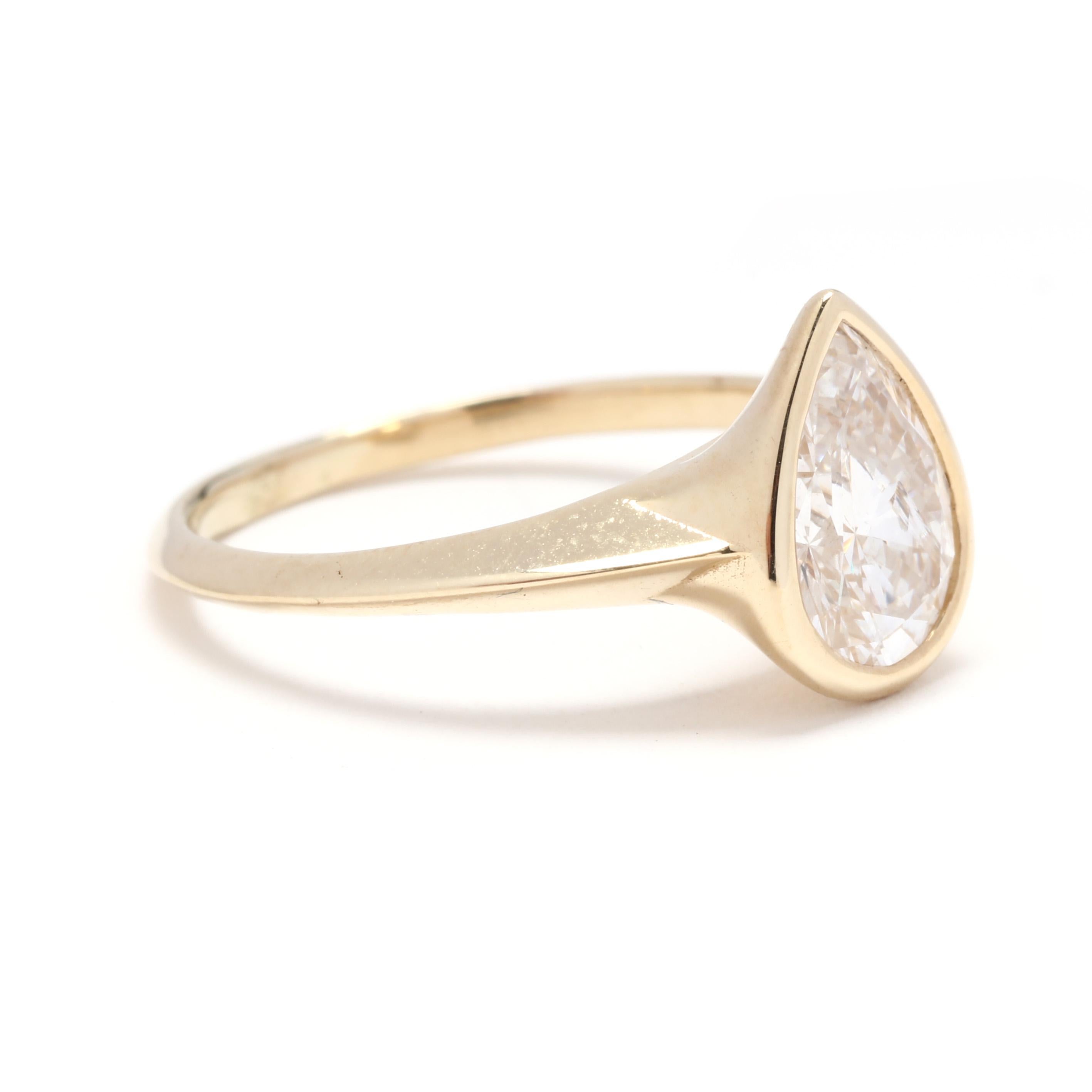 A custom 14 karat yellow gold pear diamond solitaire engagement ring. This minimalist ring features a bezel set, pear cut diamond weighing approximately 1.35 carat and with a tapered knife edge band.

Stones: 
- diamond, 1 stone
- pear cut
- 9.25 x