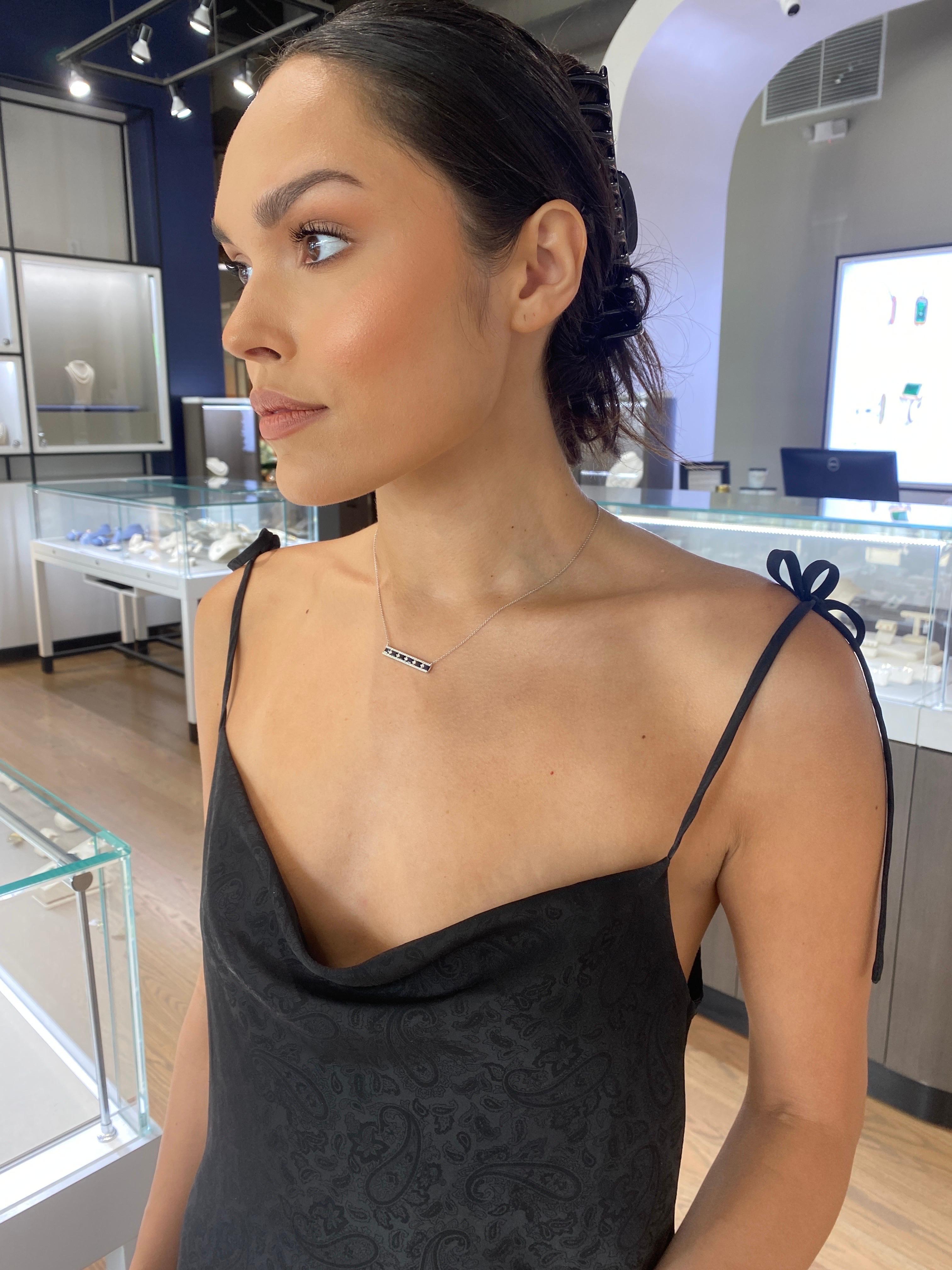 This bar necklace features 1.35 carat total weight in princess cut sapphires and 0.40 carat total weight in round diamonds set in 14 karat white gold. It is set on a 14 karat white gold chain with adjustable lobster clasp closure. 
Measurements: 18