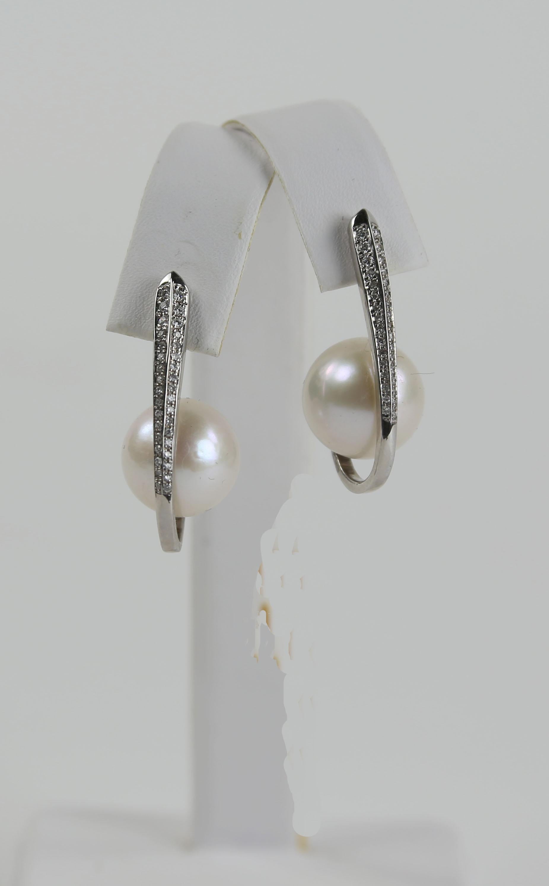 Simply Beautiful! Elegant and Stylish 13.5mm White Luminous South Sea Pearl and Diamond Earrings. Hand crafted in 18K White Gold. Each earring is accented with shimmering Round Brilliant-cut Diamonds, weighing approx. 0.25 carat (0.50 total carat