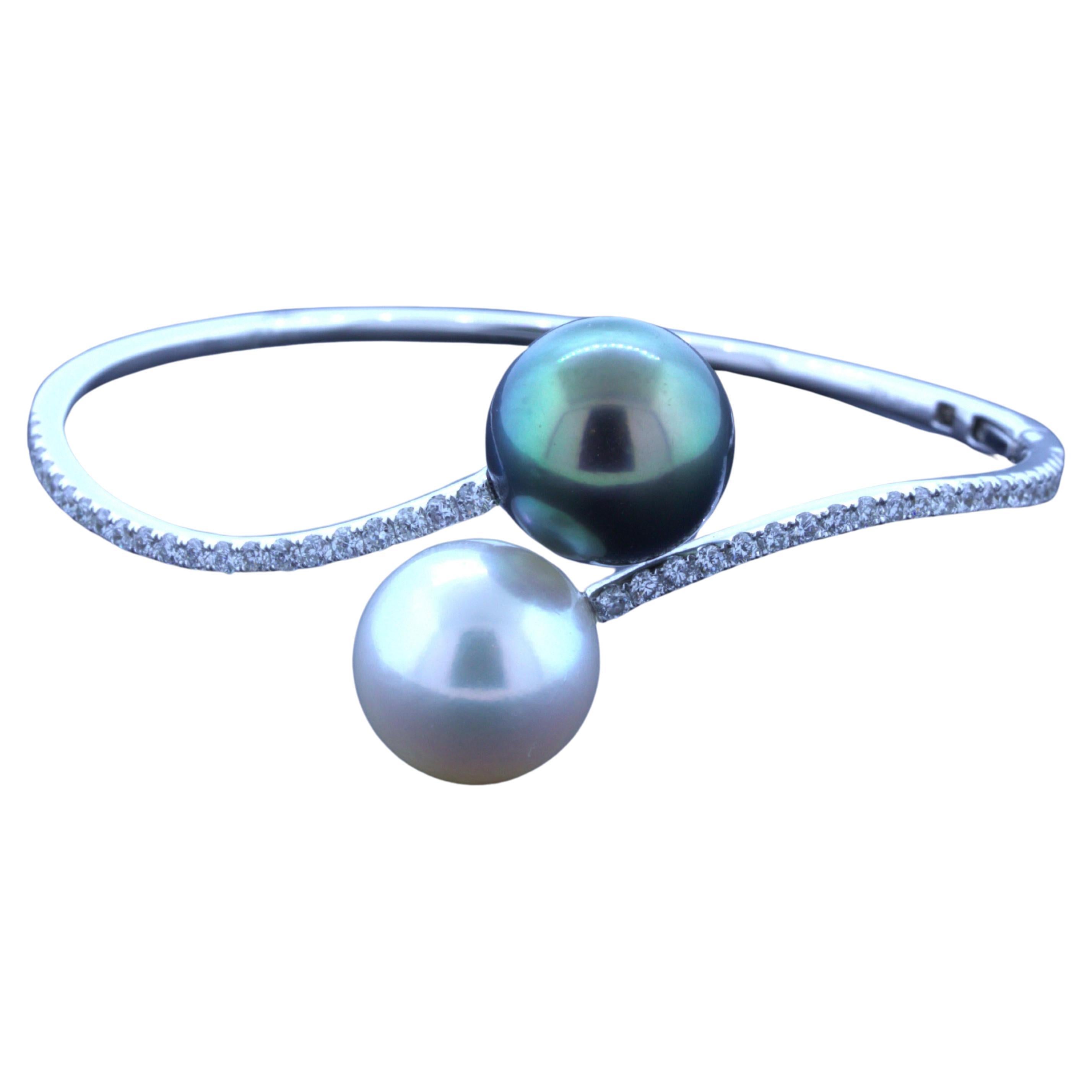 The best of both worlds! This lovely bangle bracelet has two super fine pearls, one South Sea while the other is Tahitian. They measure 13.5mm each and have excellent nacre quality and luster as the pearls glow in the light with a pink and pistachio