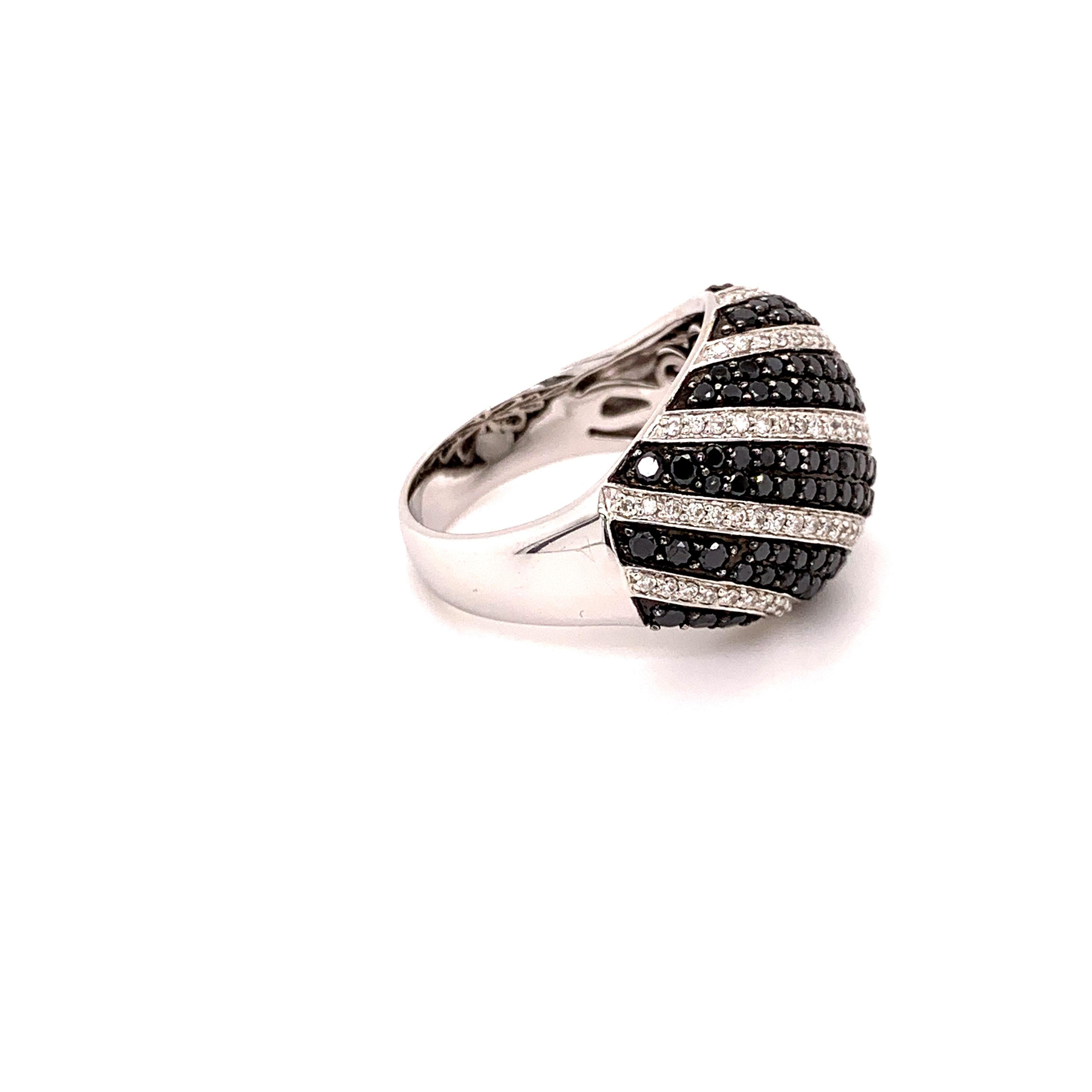 Glamorous black diamond ring. Sparkling round brilliant cut, 1.36 carats black diamond accented with round brilliant cut diamond set multiple diagonal rows. Contemporary handcrafted high dome design set in 18 karats white gold.  Statement