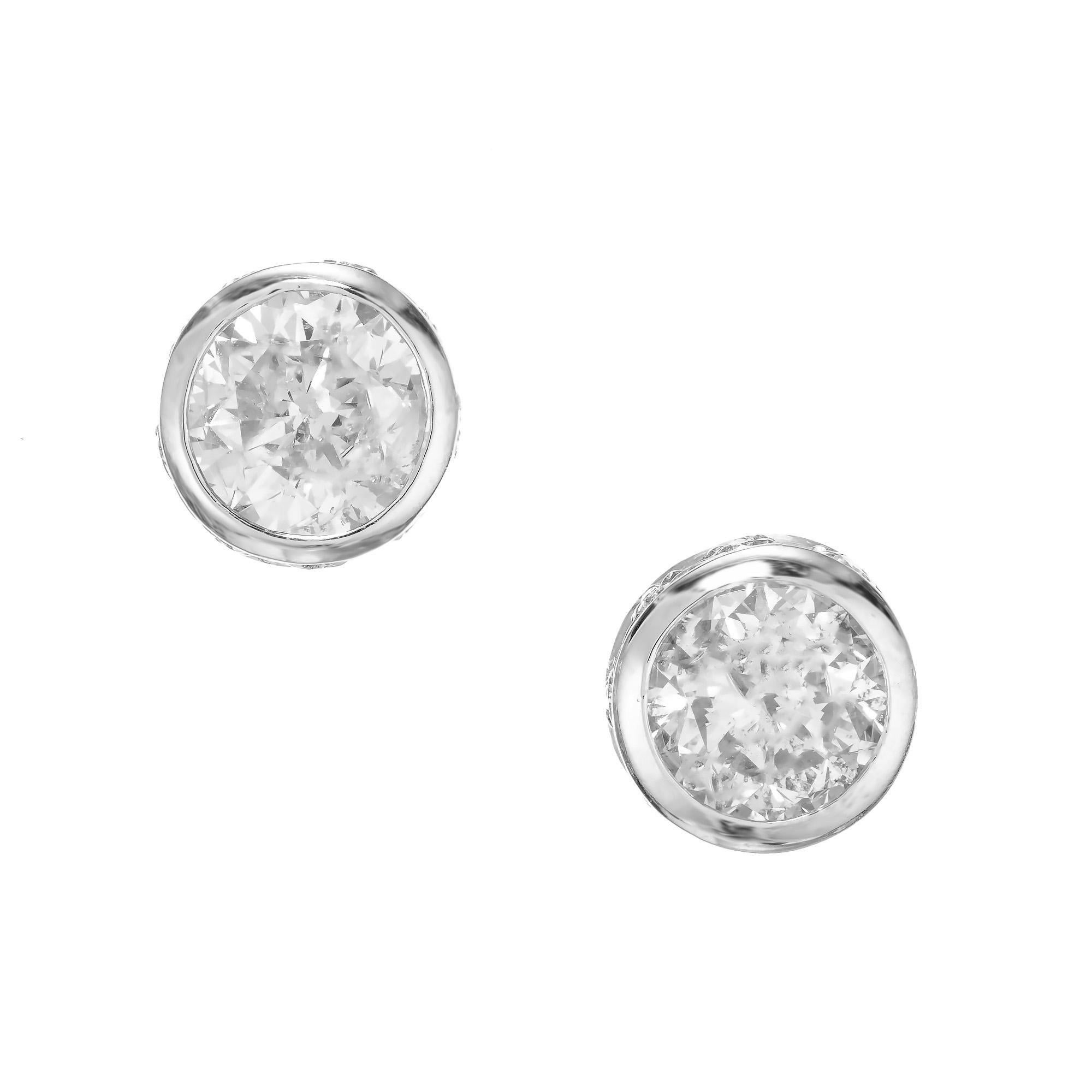 Bezel set diamond stud earrings. 2 round brilliant cut diamonds totaling 1.00cts bezel set in platinum settings with 18 round cut accent diamonds along the sides.

2 round brilliant cut diamonds, approx. total weight: 1.00cts  J-I1
18 round
