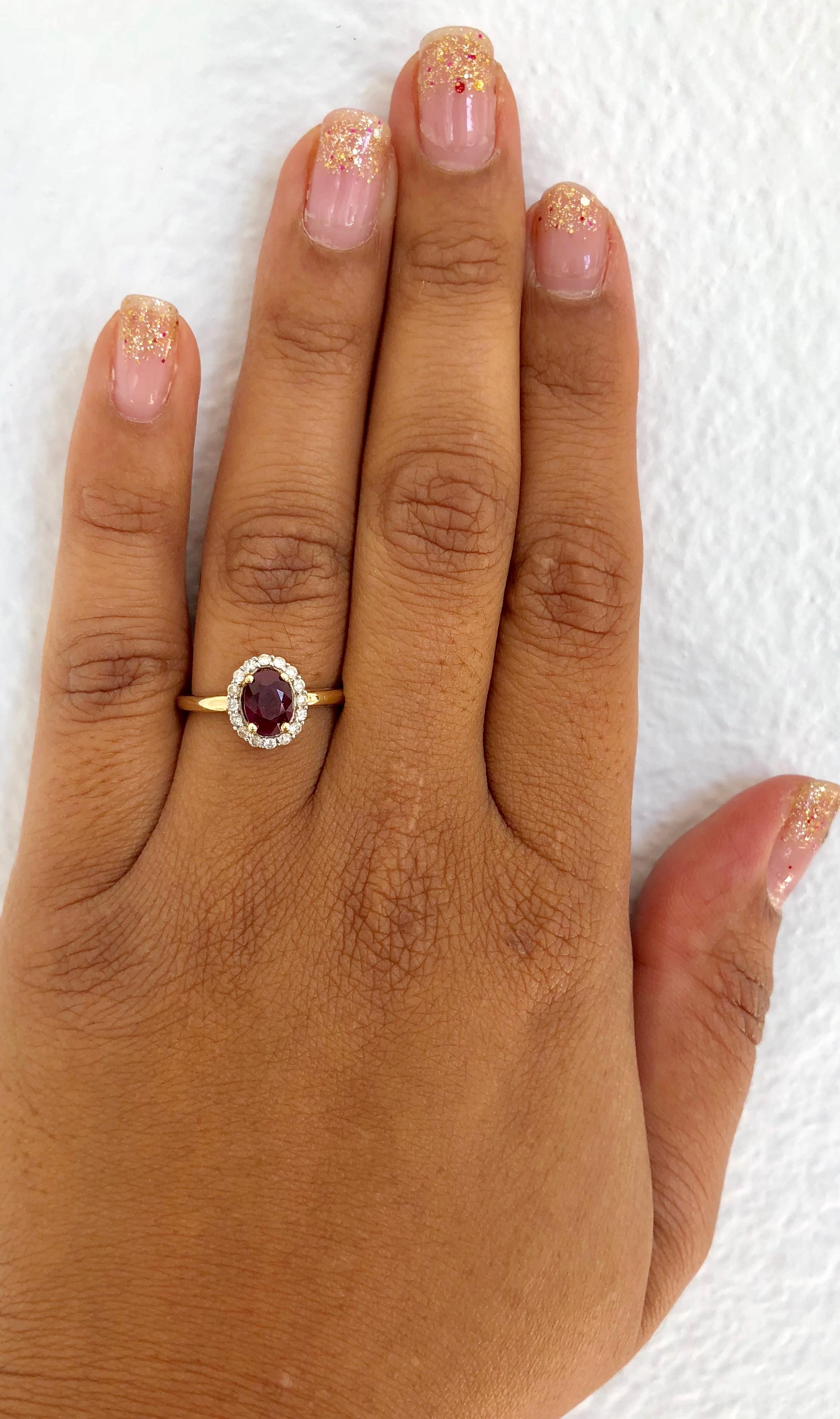 This elegant and dainty Ruby & Diamond Ring can be a modern Engagement/Promise ring. It has a Oval Cut Deep Burgundy Ruby that is 1.15 carats with a halo of 17 Round Cut Diamonds weighing 0.21 carats. The total carat weight of the ring is 1.36