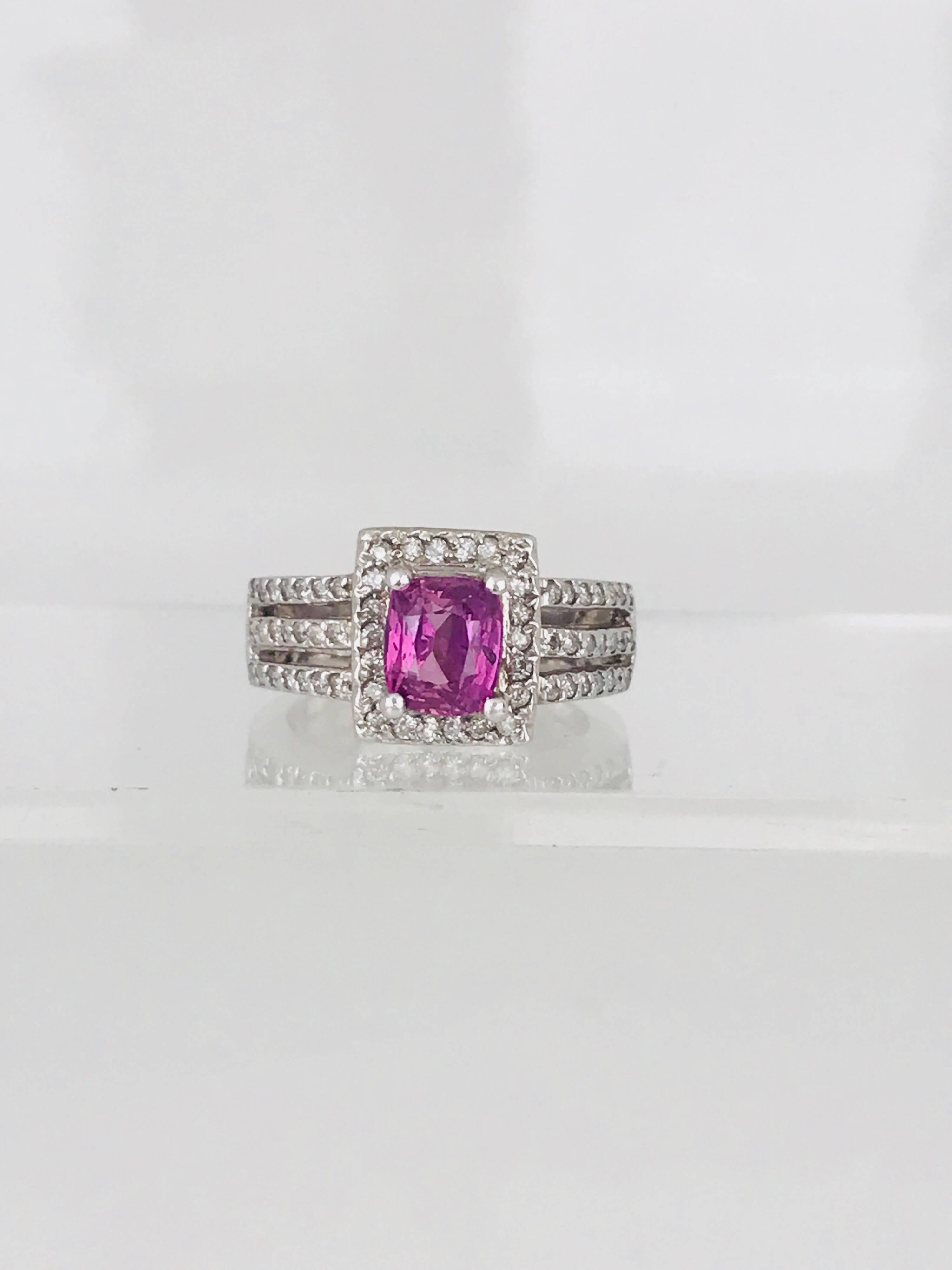 Contemporary 14 karat white gold ring features a prong-set cushion-cut pink sapphire, surrounded by a square shaped halo of pave set round brilliant diamonds and accented by a wide triple split shank set in pave set round brilliant
