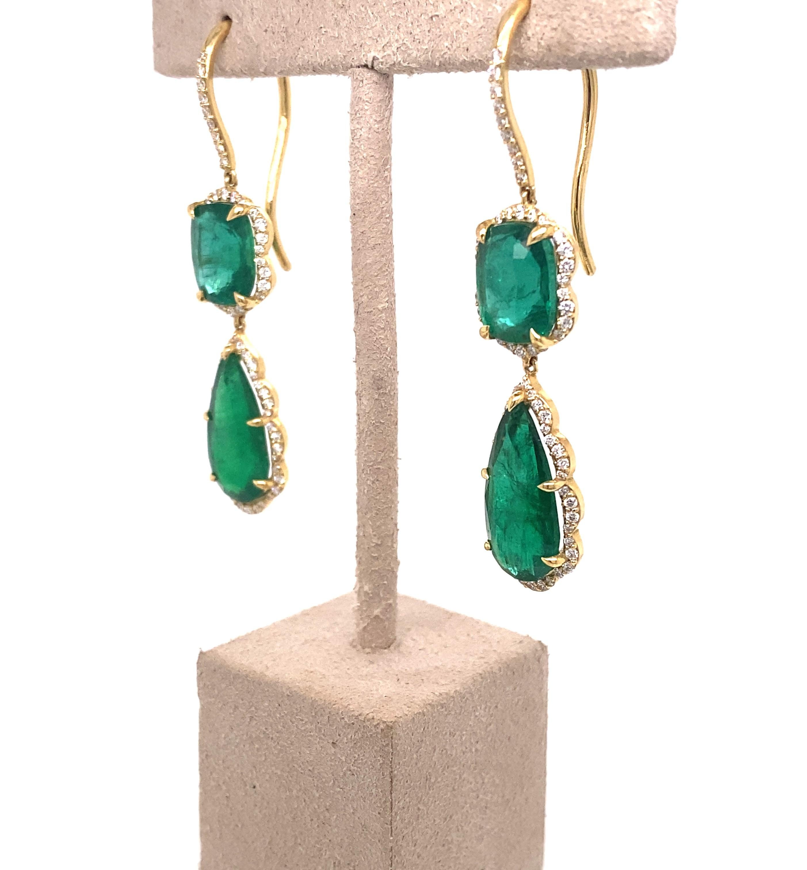 These one of a kind dangle earrings feature four Emeralds from Zambia at a total weight of 13.61 carats.  They are surrounded by a halo of round diamonds in a scallop pattern and set in 18 karat yellow gold. The french wire back has round diamonds