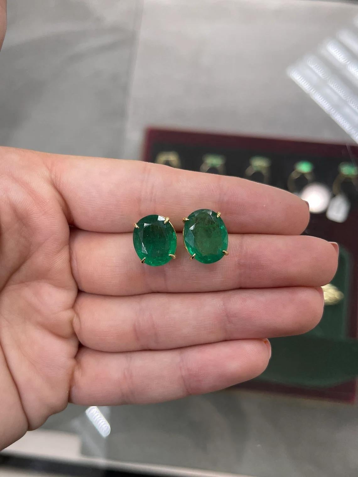 These earrings are not for the faint of heart! Featured here is a stunning set of Oval cut emerald studs in fine 18K yellow gold. Displayed are striking, dark-green emeralds with incredible size and high quality that make these so unique. The