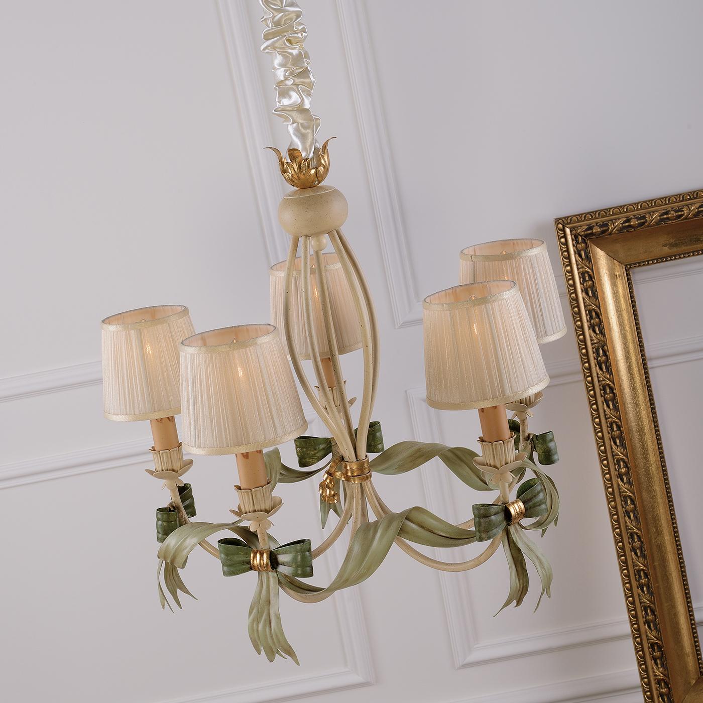 It will be hard not to notice this charming chandelier with five ivory-covered organza lampshades forming the body of the fixture. The metal details have been hand-decorated, including gold leaf accents, and a single green metal ribbon is tied