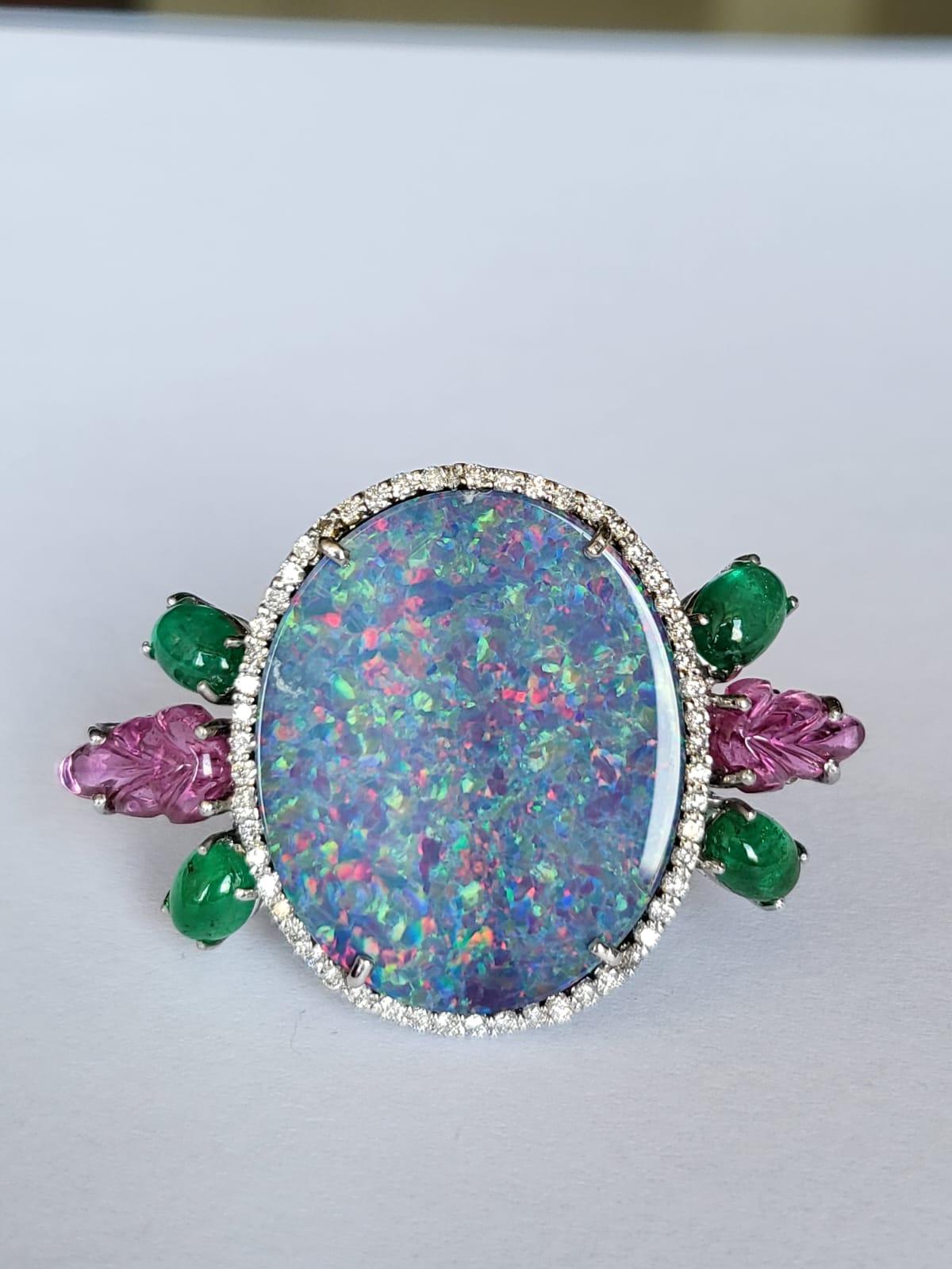 A very gorgeous and one of a kind, Doublet Opal, Emerald & Tourmaline Cocktail Ring set in 18K White Gold & Diamonds. The weight of the Doublet Opal is 13.67 carats. The Doublet is of Australian origin. The weight of the Emeralds is 1.95 carats. The