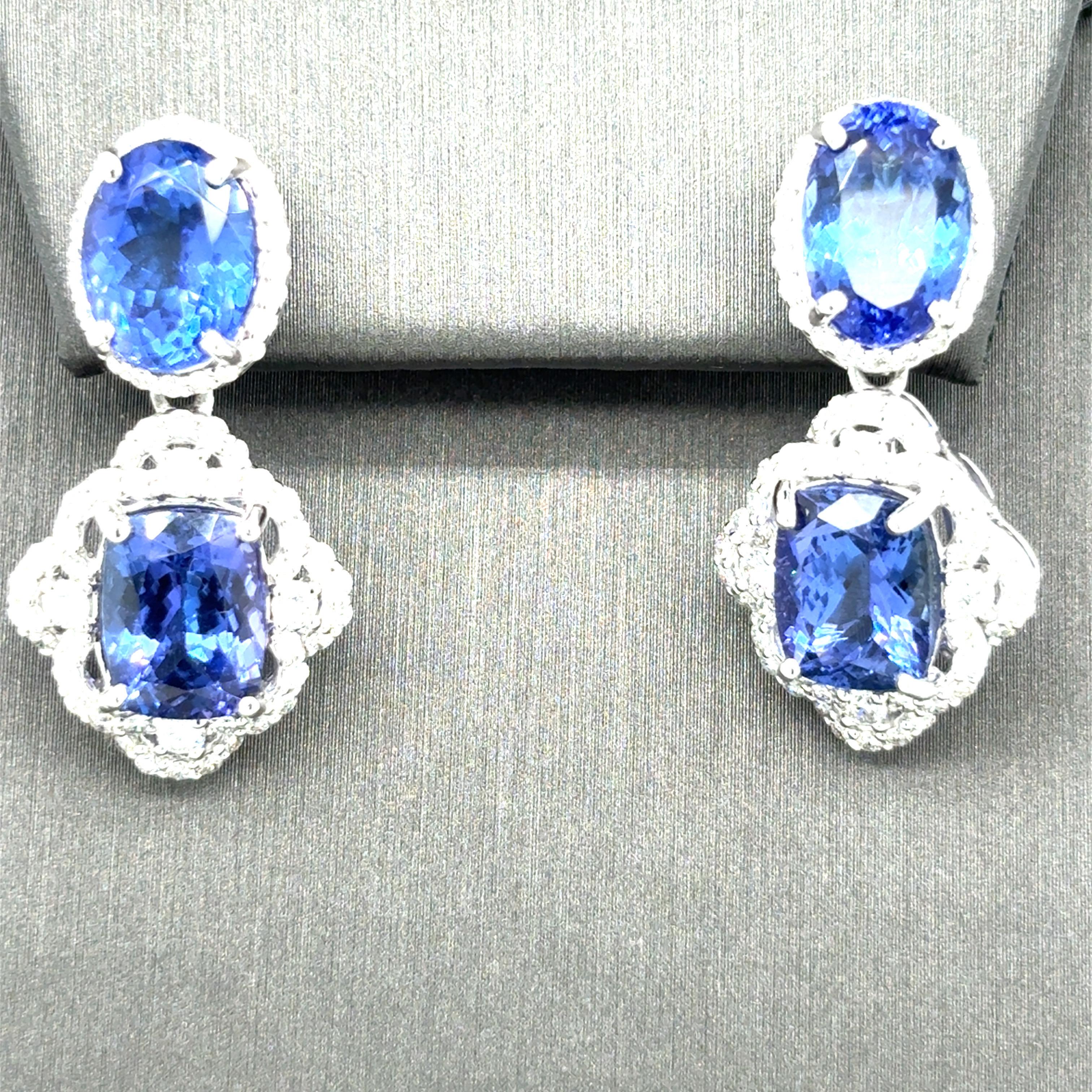 Insgesamt 13,68 Karat Tansanit stehen bei diesen atemberaubenden Ohrhängern im Mittelpunkt. Ein Tansanit im Ovalschliff ist von einem Diamantenkranz umgeben und ein Tansanit im Kissenschliff wird von weiteren Diamanten umrahmt. Das Design wird durch
