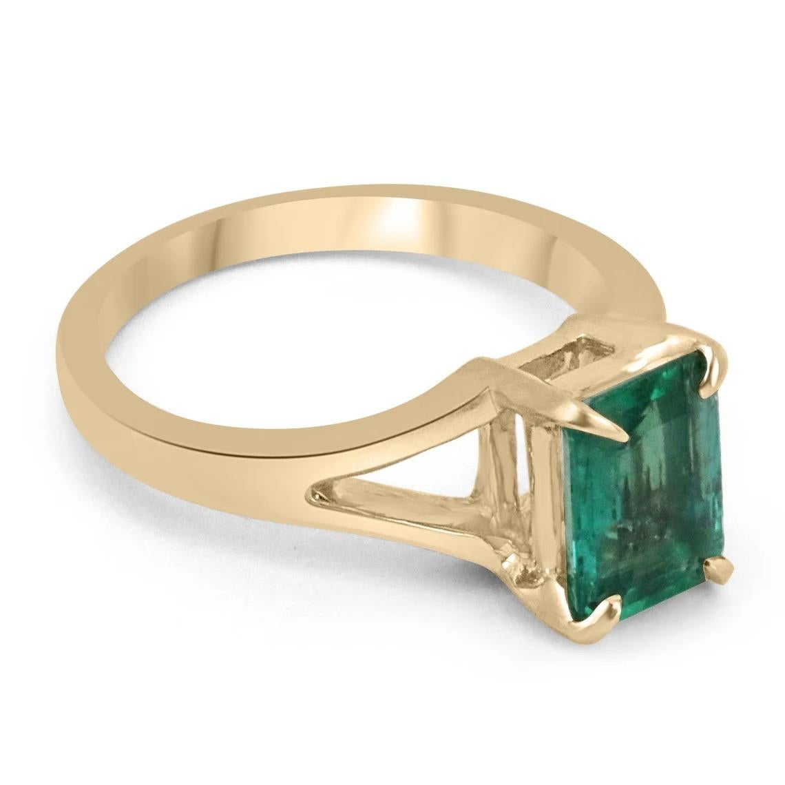 Enthrall in this stunning solitaire natural emerald ring. The gemstone showcases a fine quality Zambian emerald cut emerald with superb qualities such as excellent luster and transparency, as some of many. Set in a 14K yellow gold solitaire,
