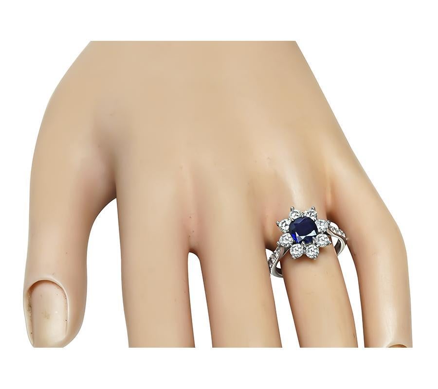 Questo è uno splendido anello in platino. L'anello è centrato da un delizioso zaffiro taglio cuscino certificato GIA del peso di 1,36 carati. Lo zaffiro è accentuato da scintillanti diamanti a taglio rotondo che pesano circa 1.30 carati. Il colore