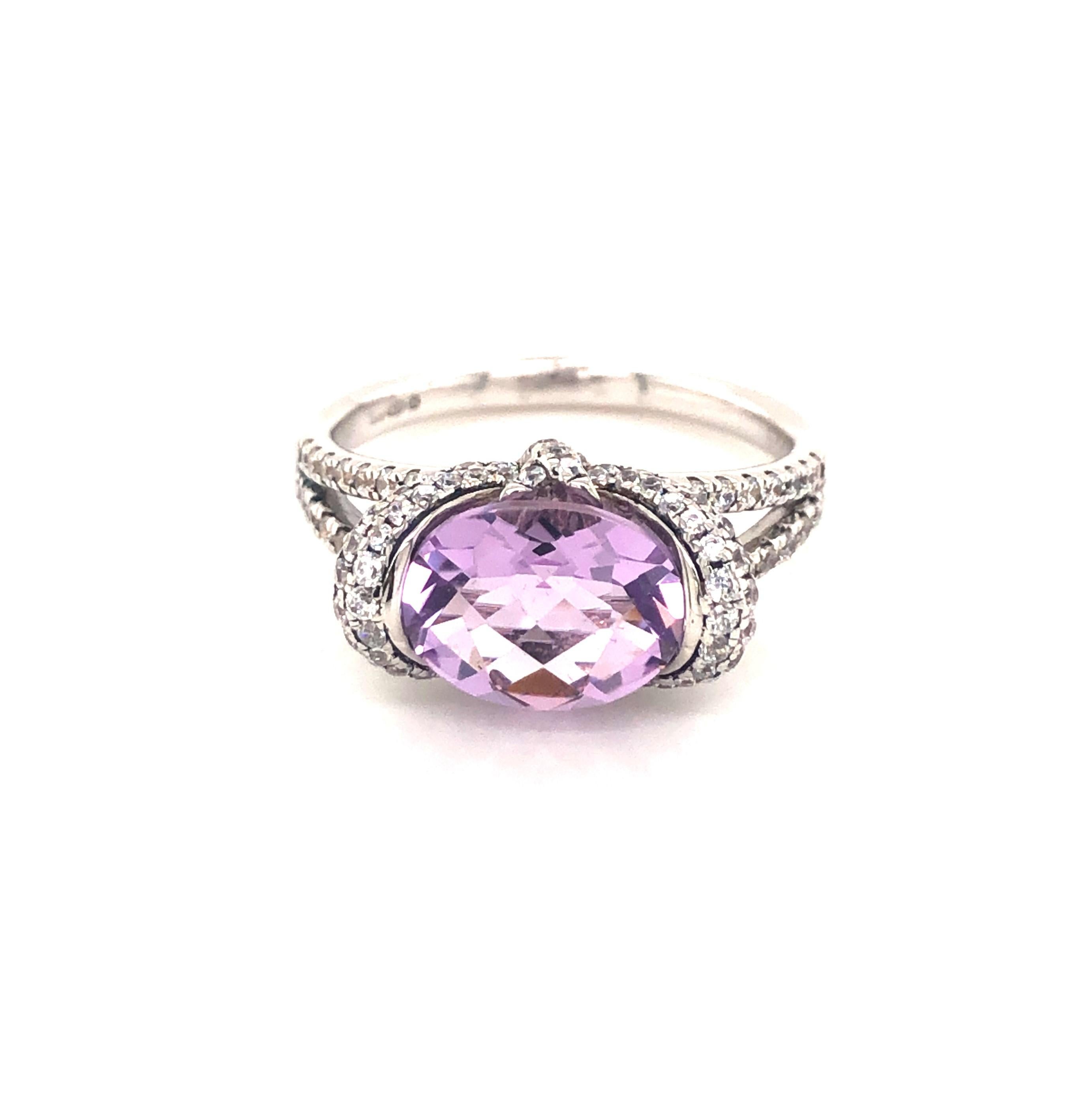 Bursting with vibrant violet hues, this beautifully multifaceted ring will attract admiring glances. 

Featuring an oval cushion cut amethyst weighing 1.37 carat, surrounded by 2.28 carat of round brilliant cut cubic zirconia, sitting majestically