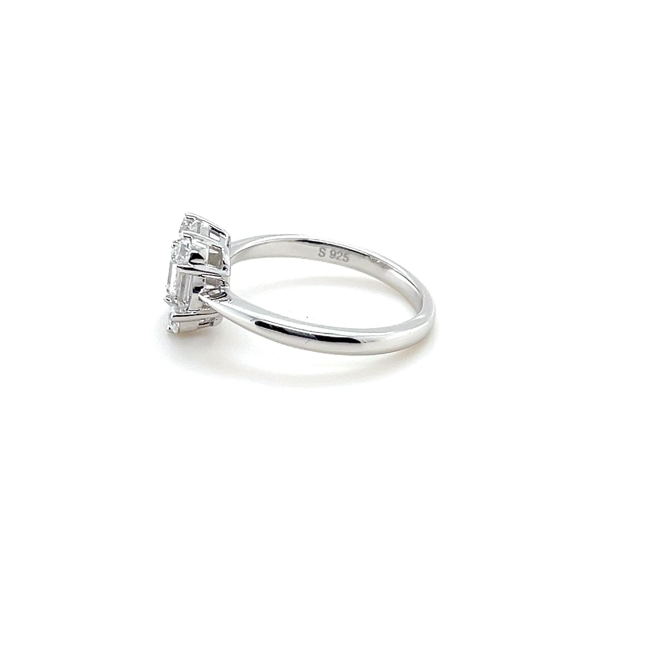This 1.37-carat cubic zirconia sterling silver baguette and round cut engagement ring is a captivating symbol of love and commitment. The centerpiece of the ring is a sparkling emerald cut cubic zirconia, expertly crafted to catch the light and