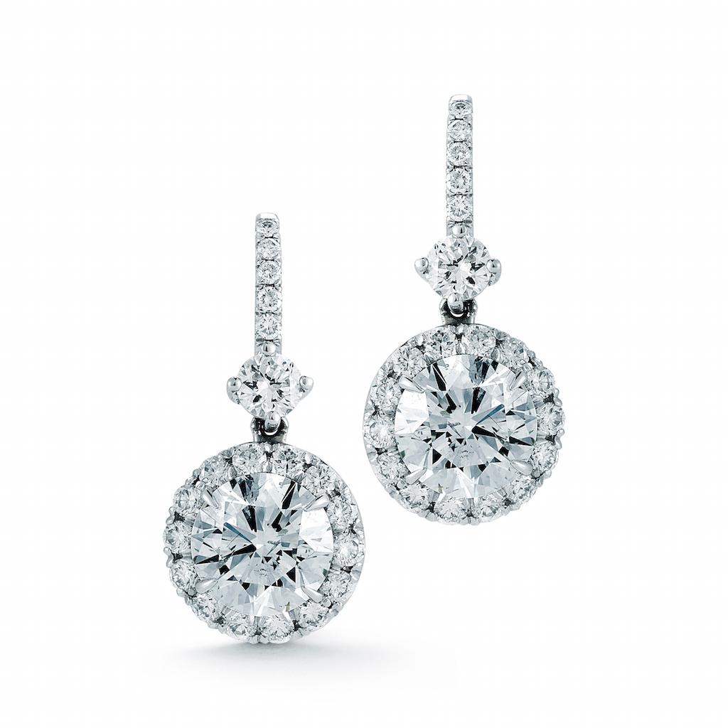 1.37 Carat total weight Dangling Halo Diamond Earrings in 18K White gold
Pair of dangling earrings with 2 matched round brilliant center diamonds weighing .36 carats each  complemented by a diamond halo consisting of 36 round brilliant cut diamonds 