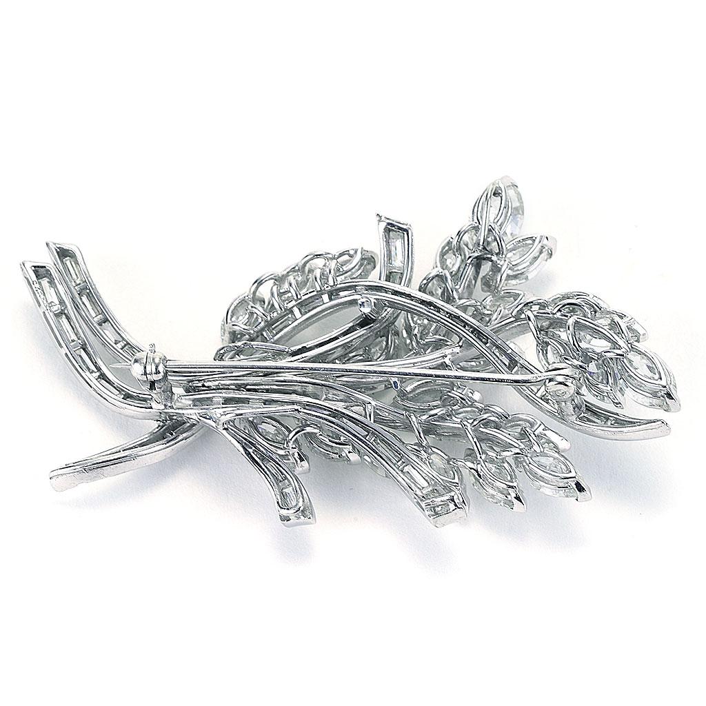 This pin is made of platinum and weighs 17.50 DWT (approx. 27.22 grams). It contains 26 marquise G-I color and SI clarity diamonds weighing 11.50 CTTW, 37 tapered baguette G-H color and VS clarity diamonds weighing 2.50 CTTW. Dimensions: 2.5