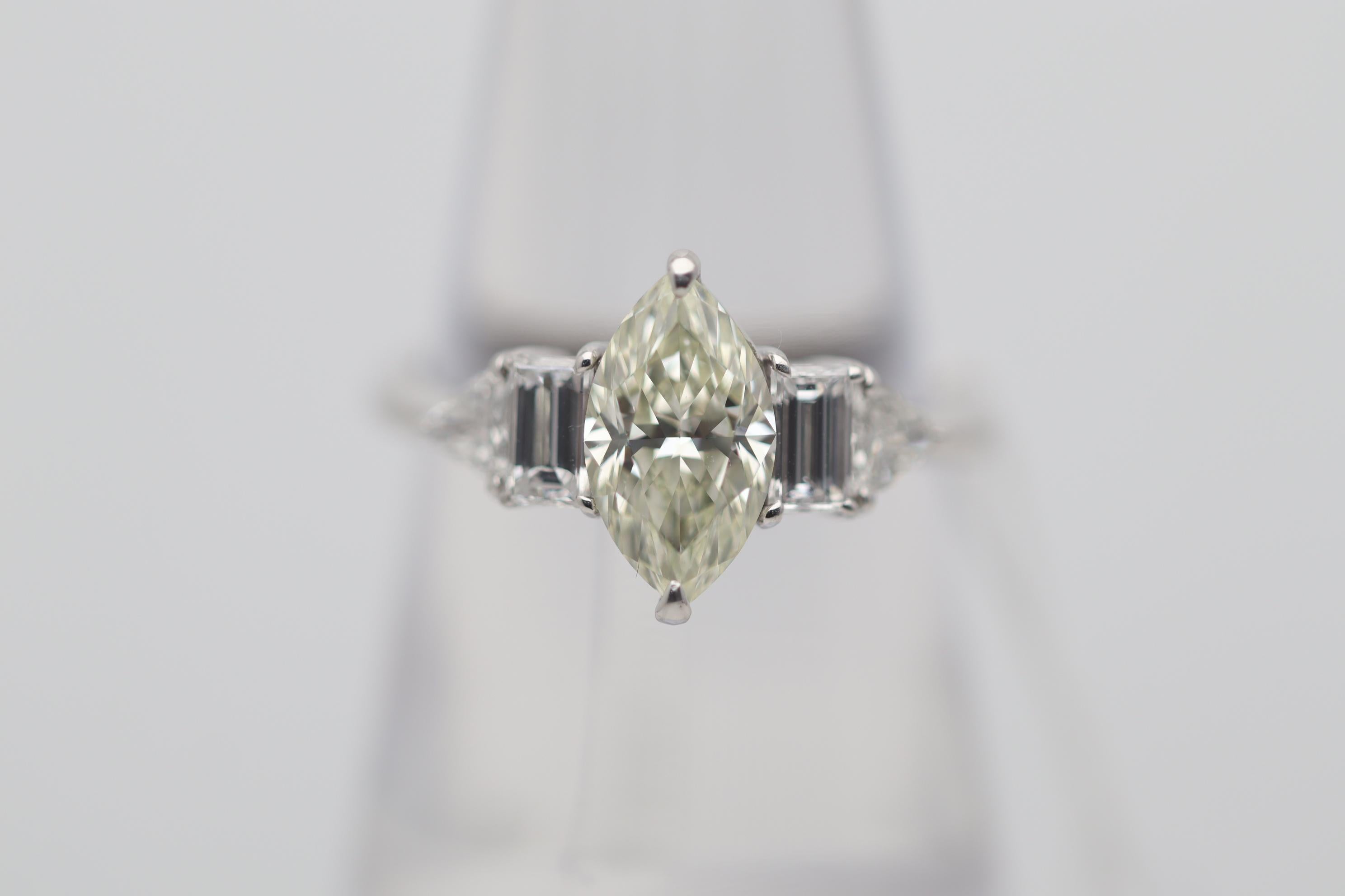 A lovely engagement ring featuring a 1.38 carat marquise-shape diamond. The marquise diamond has a fancy light yellow color which is even and makes the diamond appear to glow! Adding to that it has a clarity grade of VS2 making the stone clean