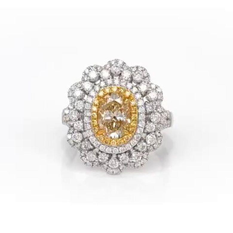 This exquisite 2.89 total carat handcrafted diamond engagement ring is as unique as the hand destined to wear it. 
At its center, a breathtaking 1.38 carat fancy yellow diamond is embraced by 0.18 carats of round yellow diamonds, set on four prong