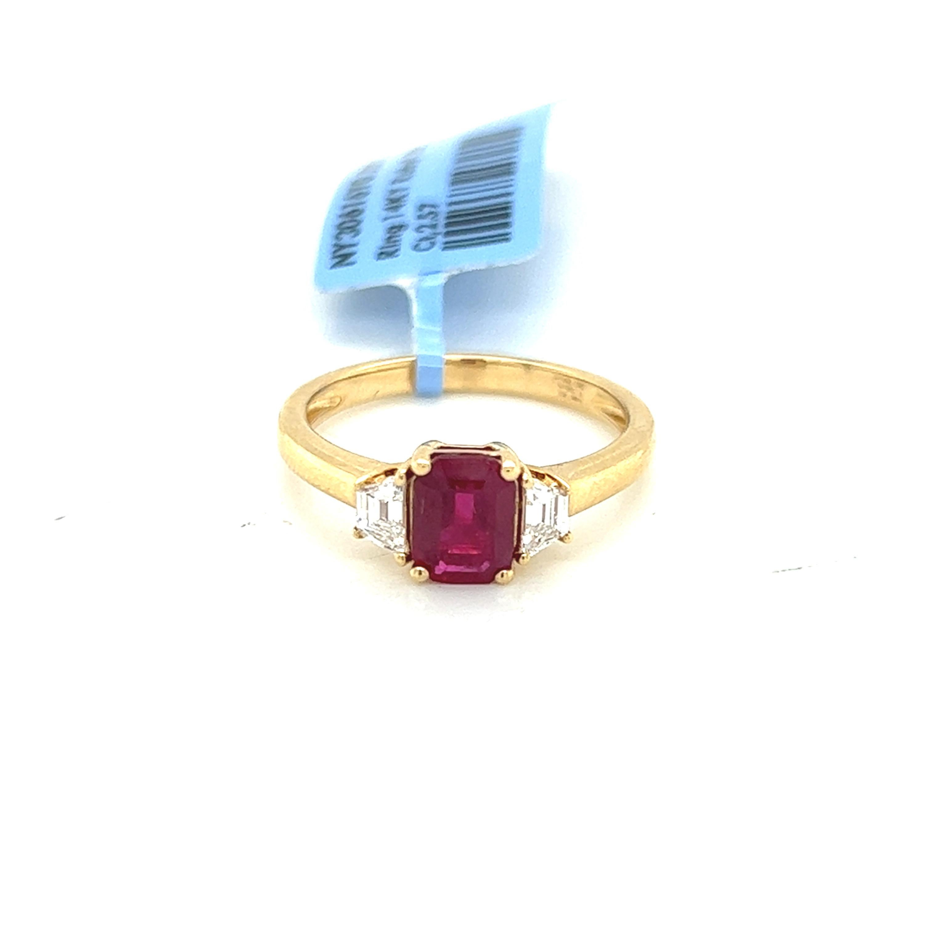 Introducing our exquisite 1.38 Carat Ruby and Diamond Three Stone Ring, a captivating piece of jewelry that radiates elegance and sophistication. The centerpiece of this stunning ring is a natural 1.38 carat emerald-cut ruby, of exceptional quality