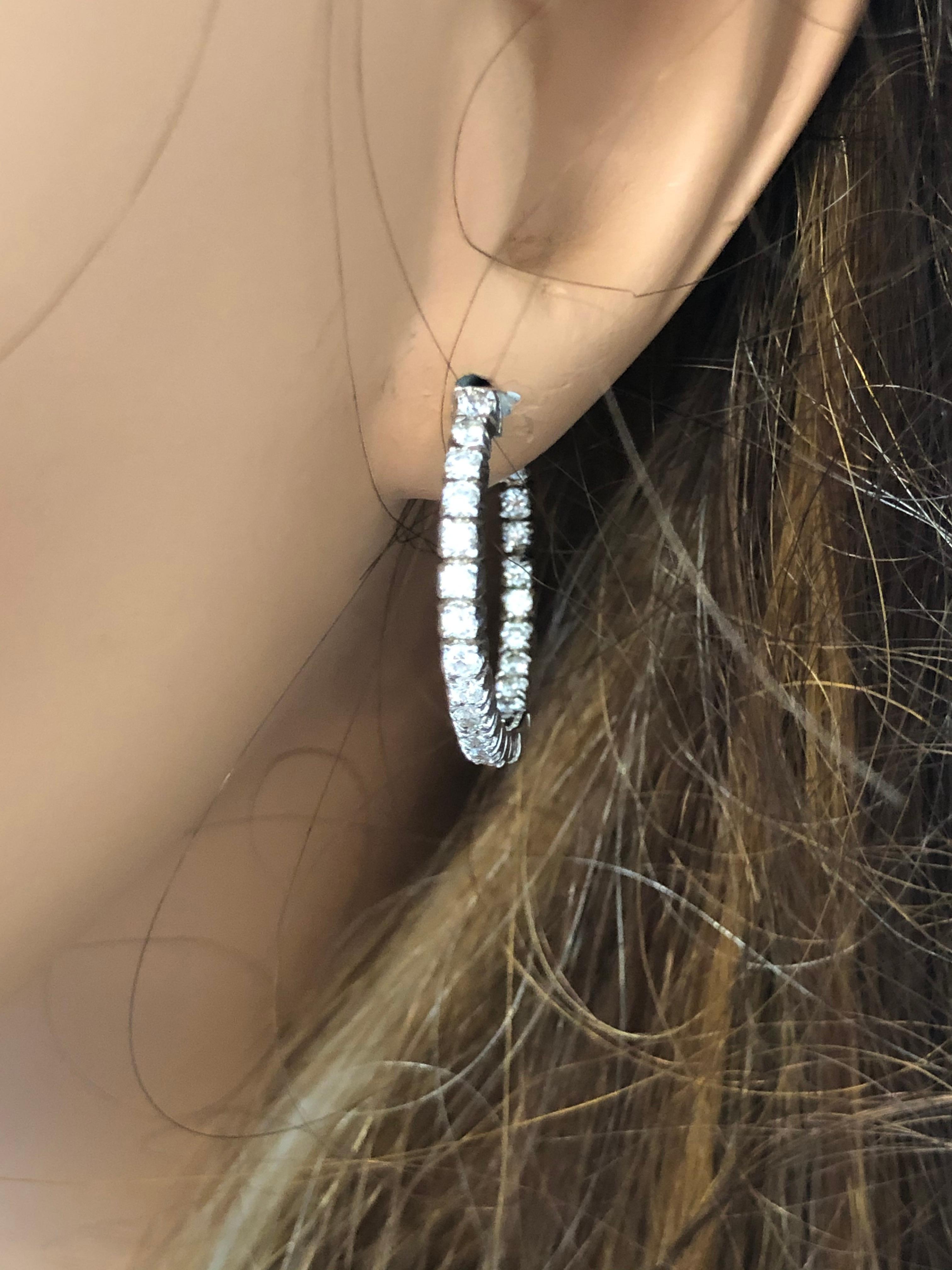 Designed in brightly polished 14 karat white gold, this gorgeous pair of inside out hoop earrings are the perfect fine jewelry accessory to treasure for a lifetime. These spectacular hoops feature 48 sparkling round brilliant cut diamonds prong set