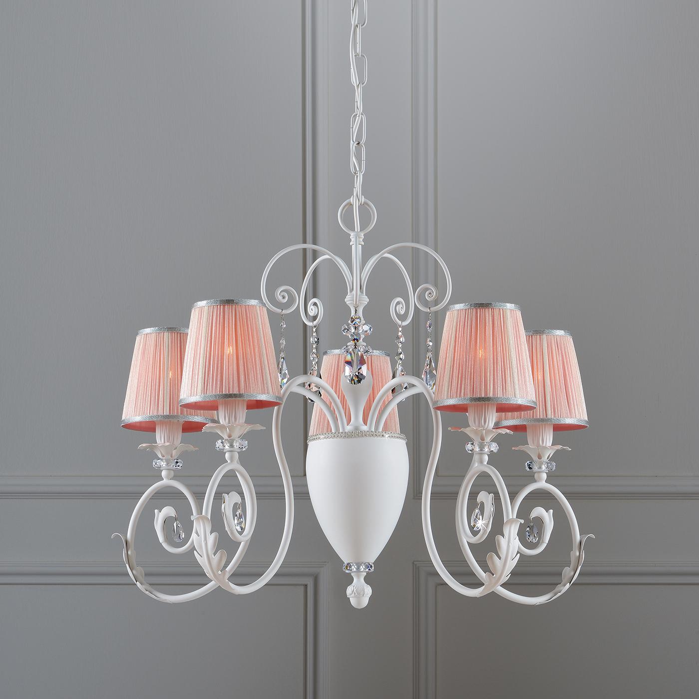 A delicate and elegant chandelier perfect to deliver a great atmospheric illumination. The structure is in white metal characterized by some crystal ornaments. The organdy lampshades in pink create a bit of contrast with the white structure which is