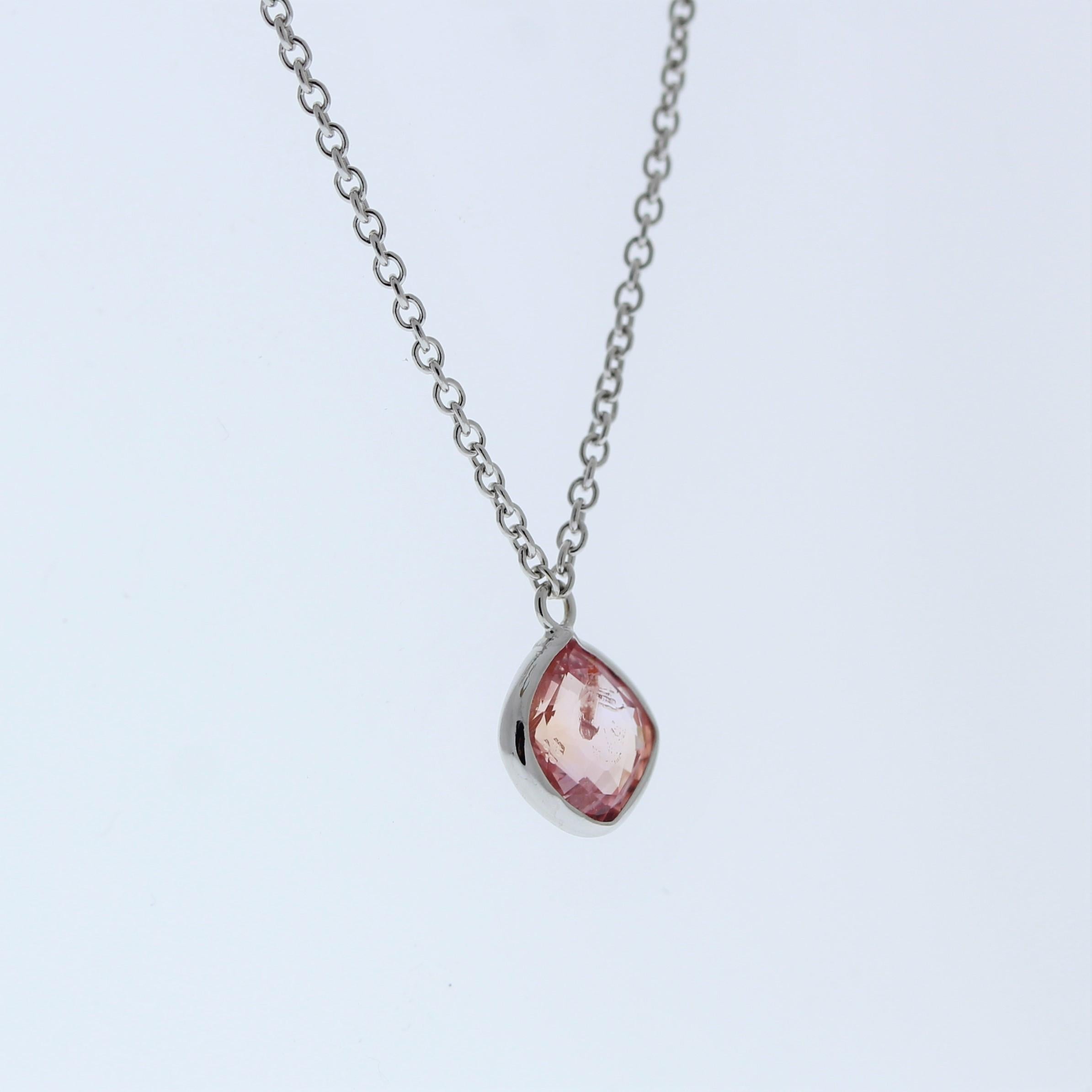 The necklace features a 1.39-carat cushion-cut padparadscha sapphire set in a 14 karat white gold pendant or setting. The cushion cut and the distinctive pink-orange color of the padparadscha sapphire against the white gold setting are likely to