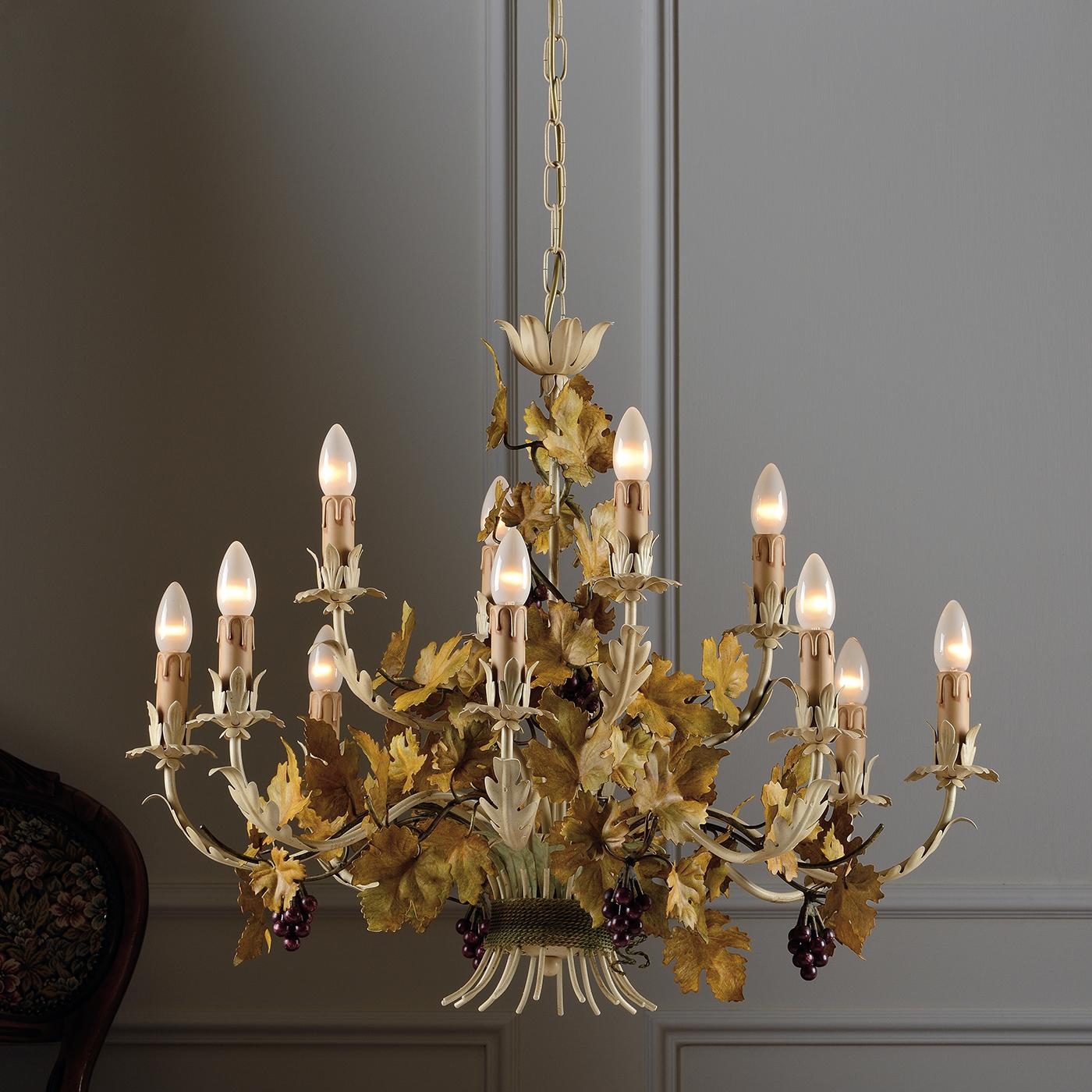 Questo delizioso lampadario in metallo anticato parla di epoche passate ed è decorato a mano con foglie d'uva dorate e piccoli grappoli d'uva. Appeso a una catena di metallo e con dodici lampadine che poggiano su bracci rovesciati, questo lampadario