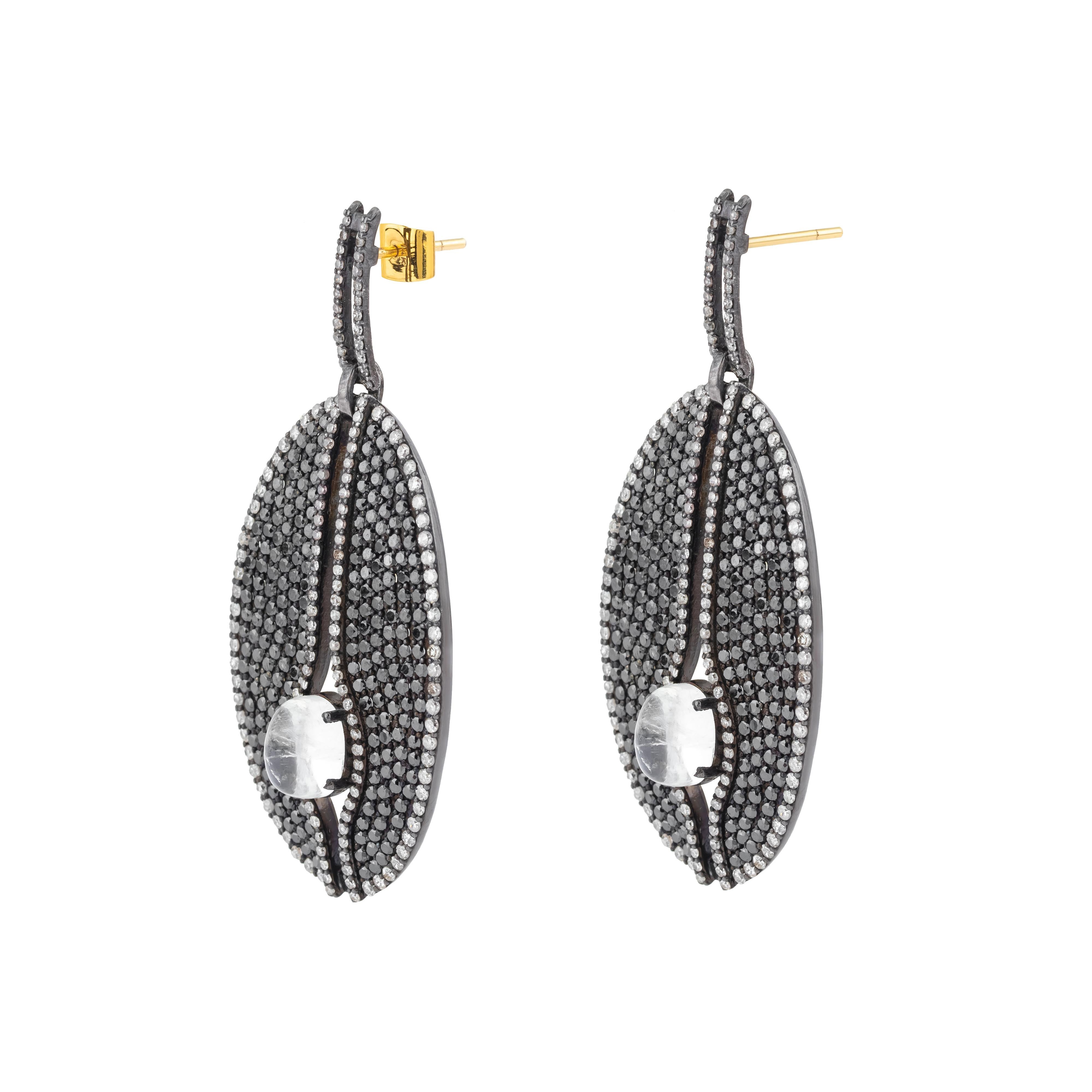 Sospesi con grazia, questi orecchini a goccia con diamante da 13,91 carati, diamante nero e pietra di luna incarnano una rara unione di eleganza e arte moderna. Ogni orecchino è caratterizzato da un'armoniosa miscela di diamanti luminosi e pietra di