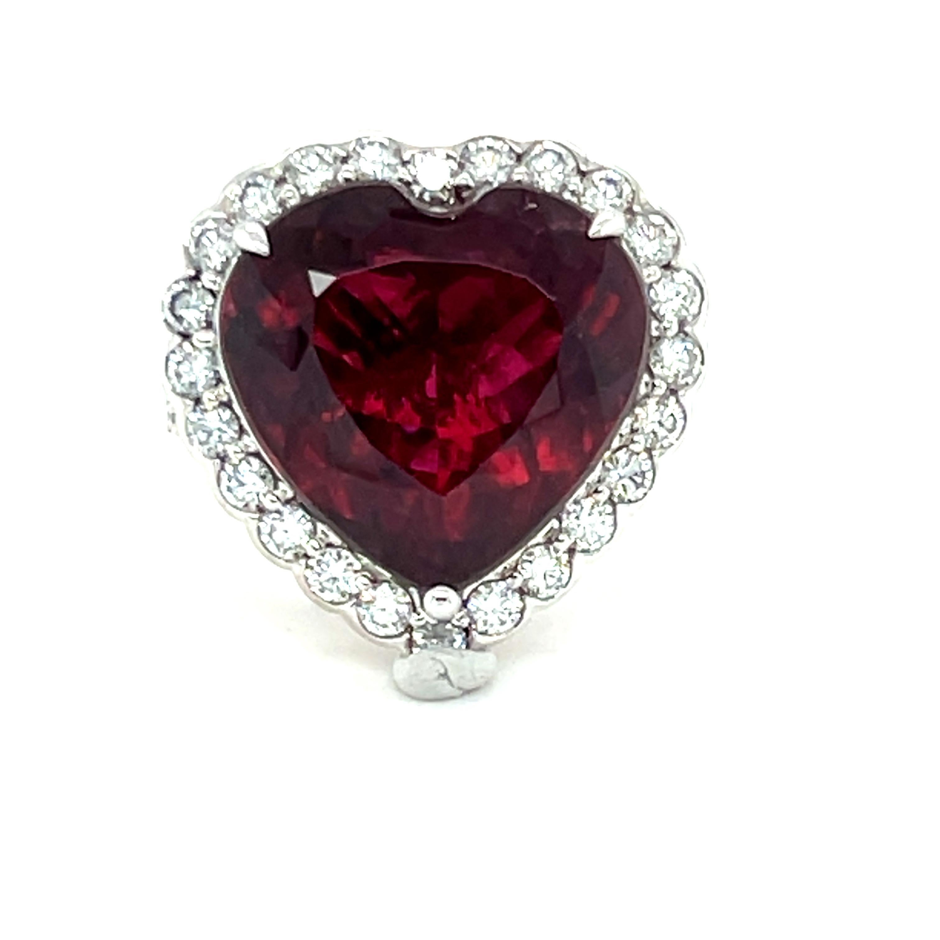 
This stunning ring features a 13.98-carat heart-shaped rubellite tourmaline in a rich, deep maroon hue, surrounded by a halo of 1.48 carats of sparkling diamonds. The intricate back gallery adds to its elegant design, while the band, crafted in 18K