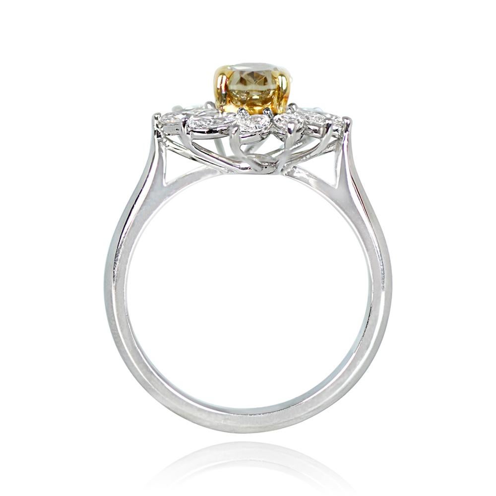 This distinctive cluster engagement ring showcases a unique 1.39-carat oval-cut yellow-brown diamond. It is encircled by a halo of marquise-cut diamonds, forming a floral motif. The side diamonds contribute approximately 0.92 carats in total weight.