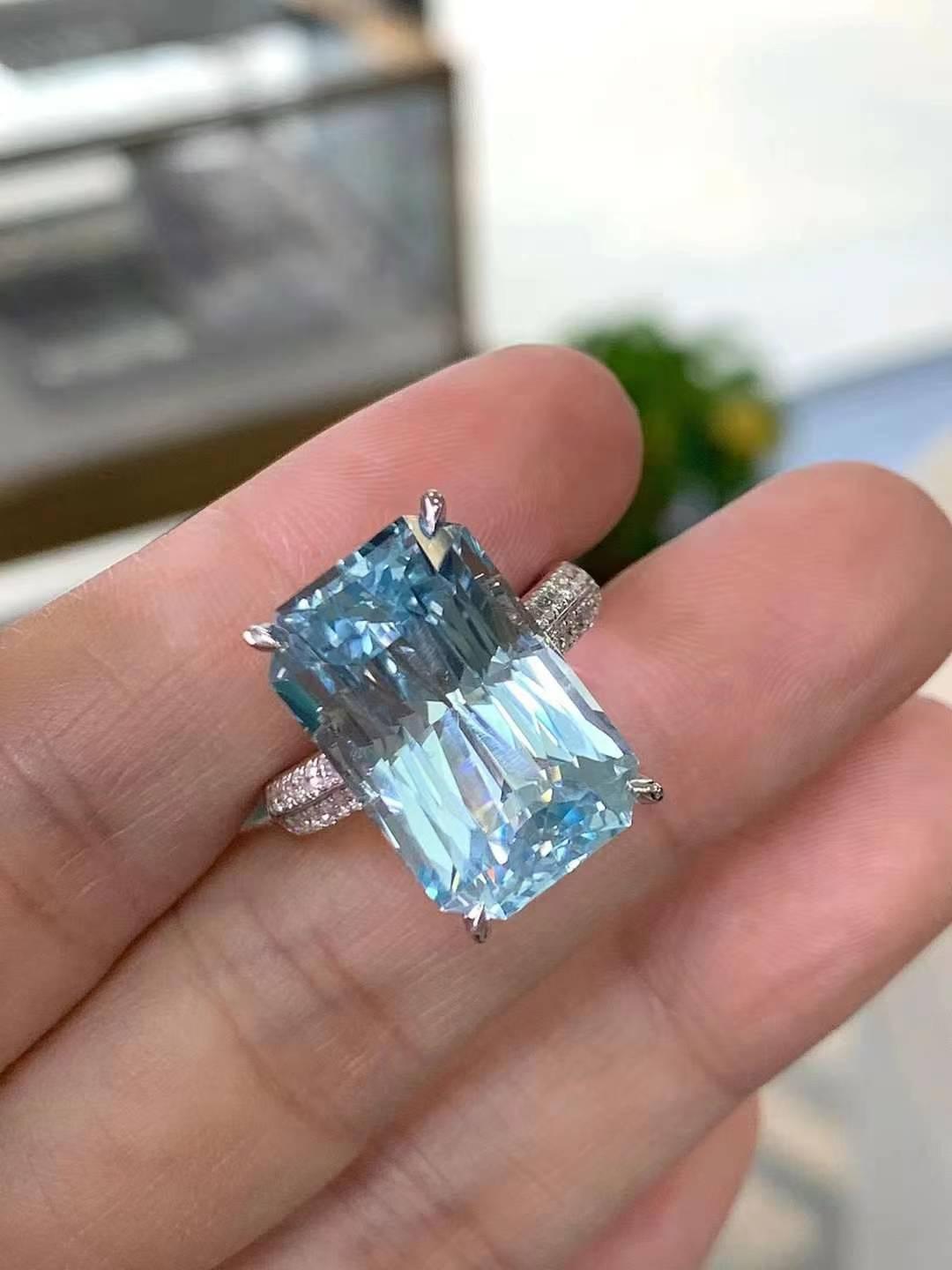 Laissez-vous séduire par l'élégance de cette époustouflante bague en or blanc 18 carats sertie d'une aigue-marine de 13 carats et d'un diamant blanc de 0,43 carats. La pièce maîtresse, une étonnante aigue-marine de 13ct, irradie d'une captivante