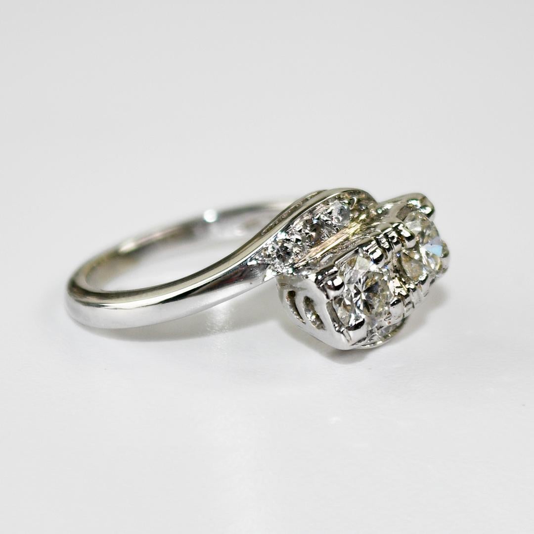 Bague vintage en or blanc 13k et diamants pour femme.
Tests de 55% d'or à l'aide d'un analyseur de métaux XRF.
L'anneau pèse 3.6 grammes.
Il y a deux coupes rondes brillantes, .30 carats chacune, couleur I, clarté Vs à Si.
Les côtés sont ronds,