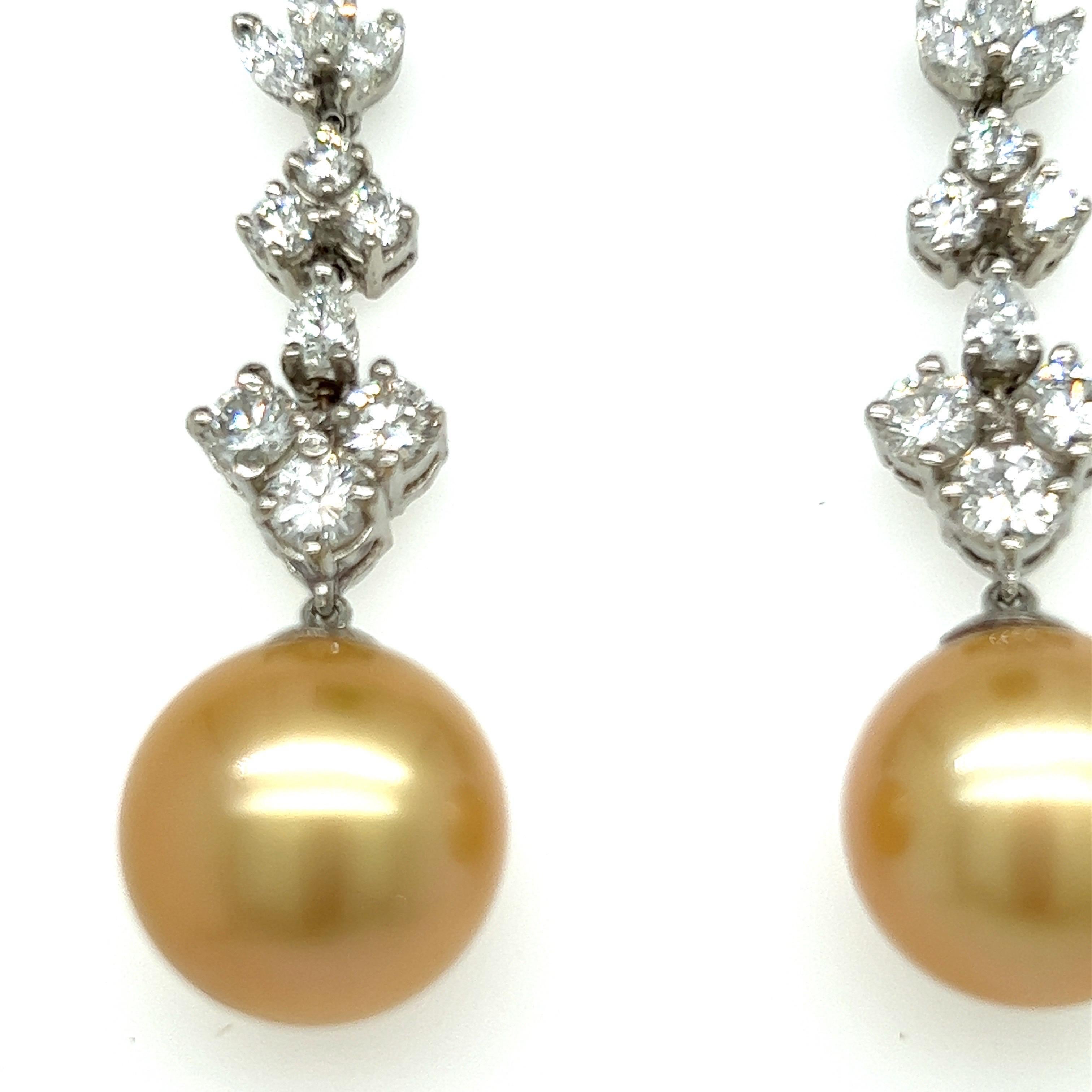 Glamouröse baumelnde Ohrringe. Hochglänzende, goldene Südsee-Perlen, die mit 2,33 Karat hochglänzenden runden Diamanten besetzt sind. Handgefertigte baumelnde Ohrringe aus 18 Karat Weißgold mit Post und Butterfly Post. 

Südseeperle: 13mm,