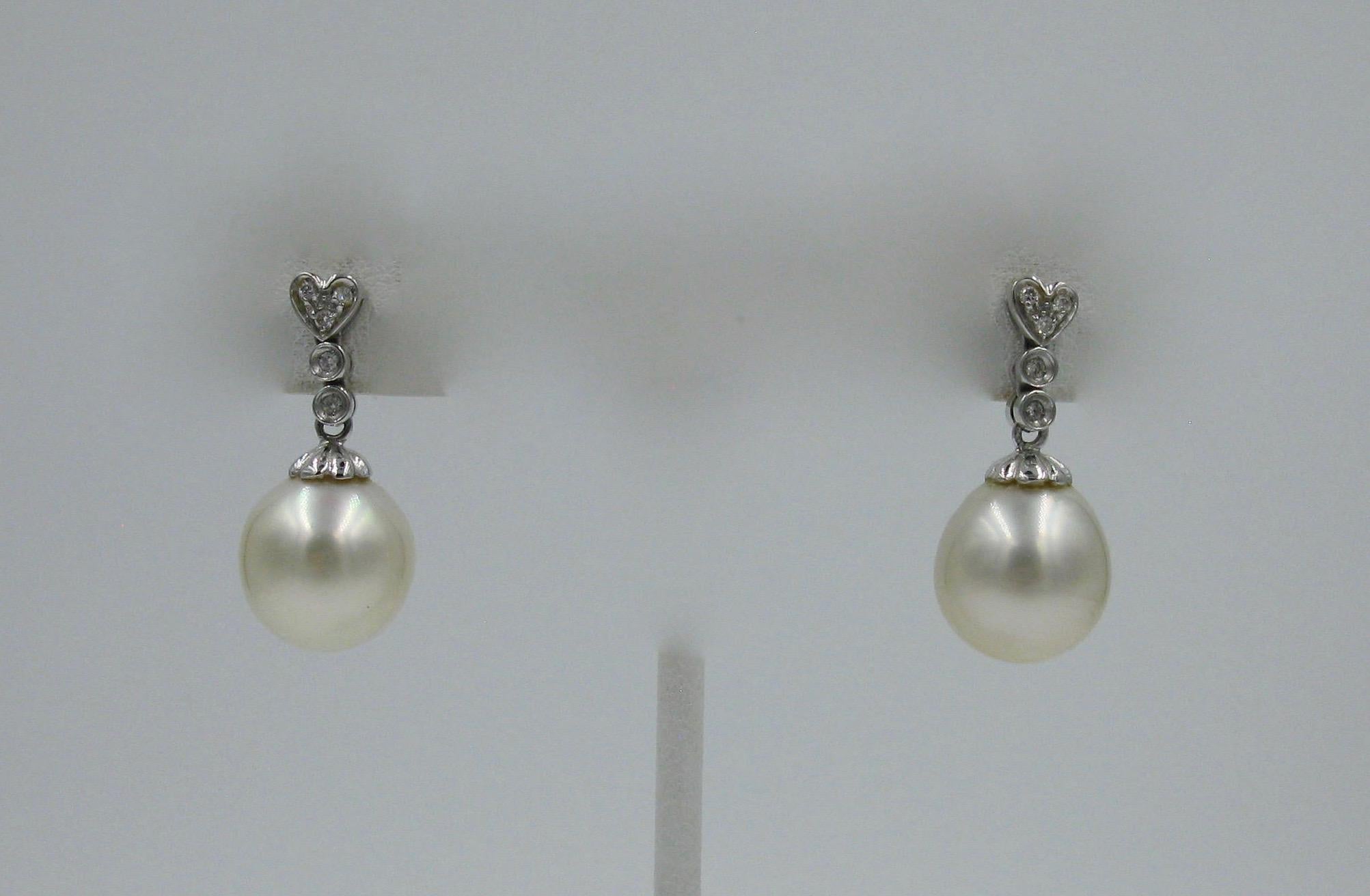 AN EXTRAORDINARY PAIR OF 13 MM SOUTH SEA PEARL AND DIAMOND EARRINGS IN 14K GOLD
The South Sea pearls are 13 mm and 12.5 mm.  The pearls hang from a ribbon of diamonds with a heart motif at the top.  The jewels are set in 14K white gold.
PEARLS
13 mm